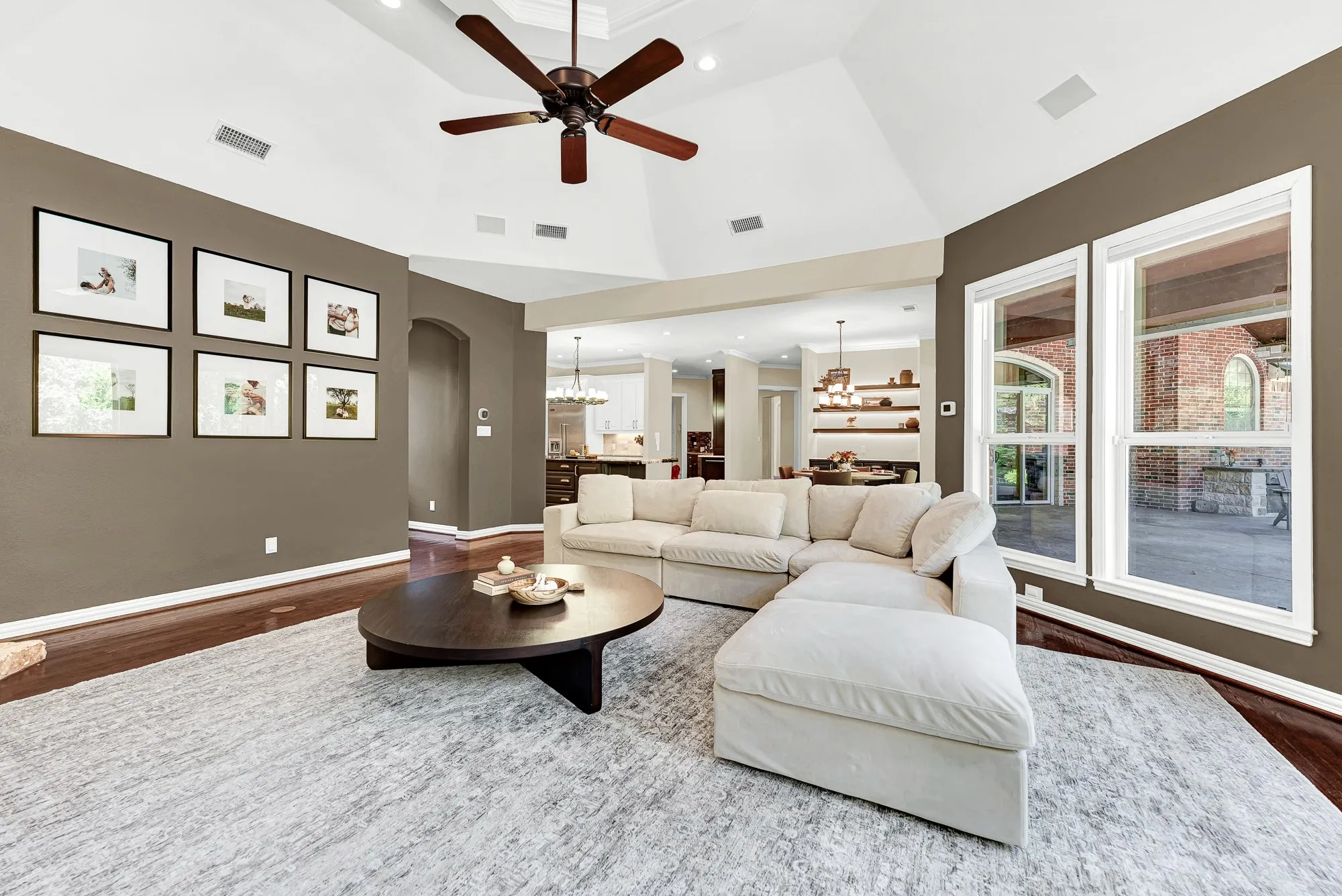 An open, arch-framed entry connects the living volume effortlessly back toward the kitchen and dining spaces. Feel the easy rhythm of daily life as family members drift smoothly between rooms after school