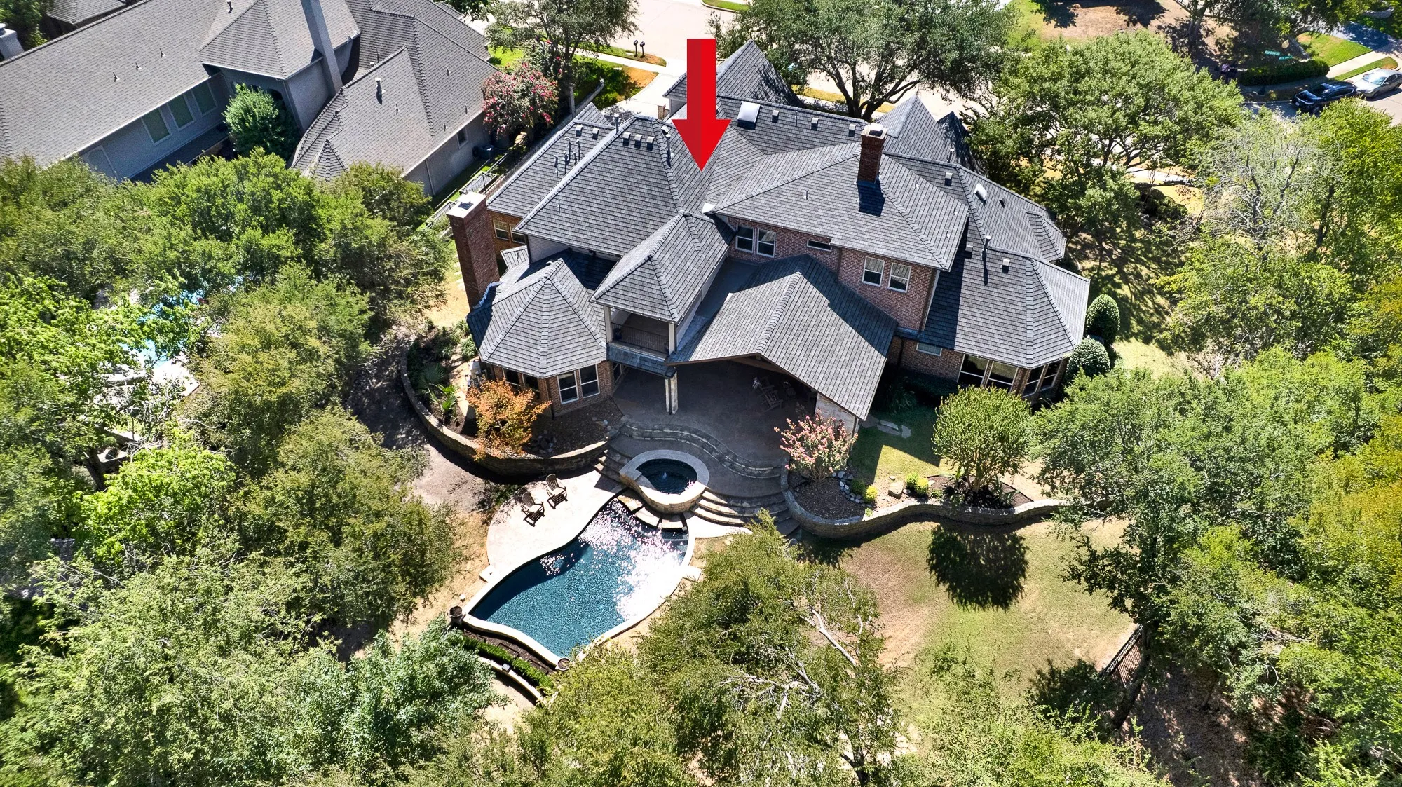 Intricate dark roof gables surround a central open patio courtyard bathed in soft natural light. Host casual afternoon pool parties where sun-seekers easily move between water, shade, and open lawn.