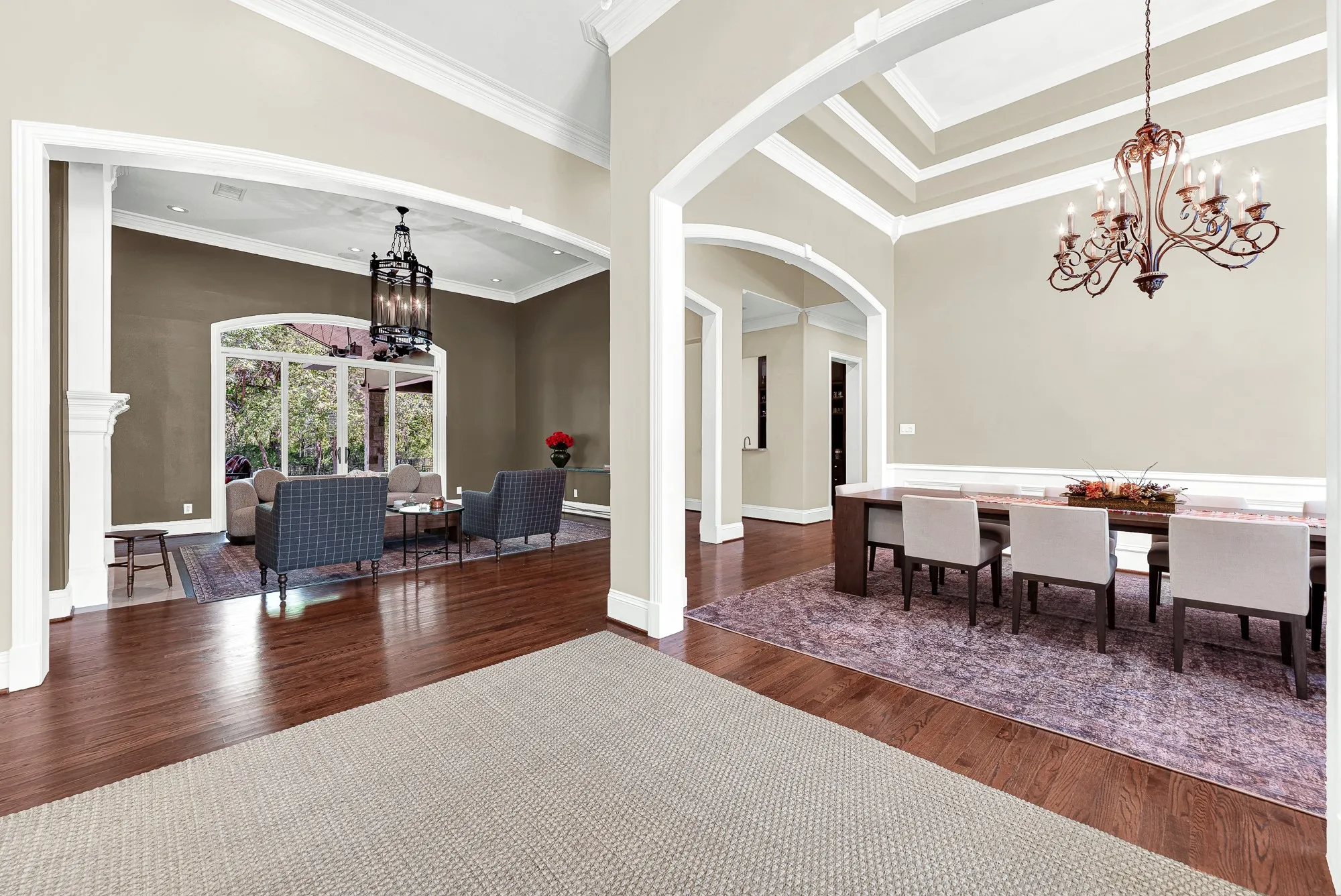 Grand arched openings create sightlines across connecting living zones while daylight bounces over polished hardwood flooring. Picture guests flowing effortlessly between conversations during a lively evening gathering