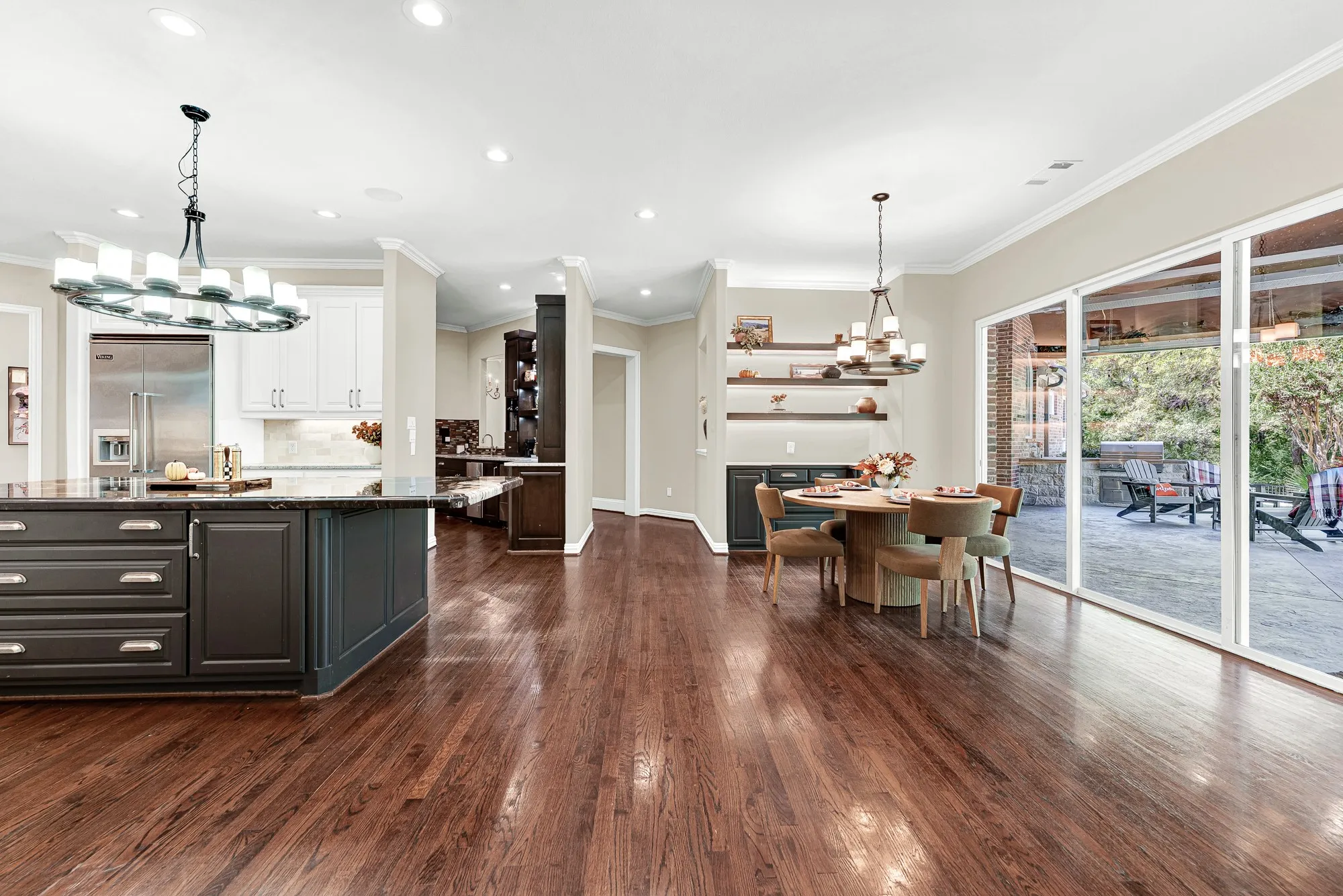 Wide glass sliding doors dissolve the boundary between rich interior brickwork and the vast covered stone patio. Host weekend game-day watch parties where guests seamlessly drift between indoor comforts and fresh open air.