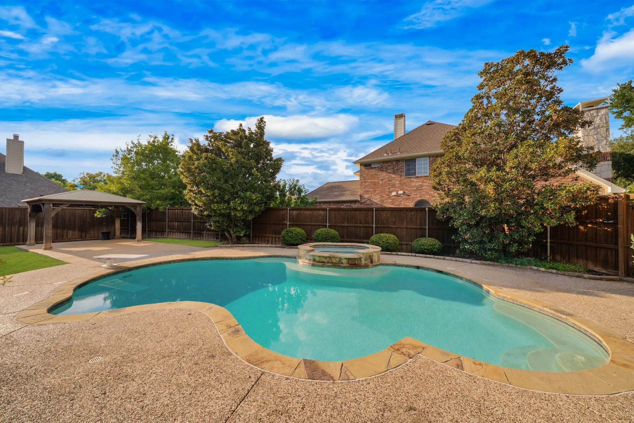 Backyard oasis featuring a freeform swimming pool, integrated spa, and expansive patio