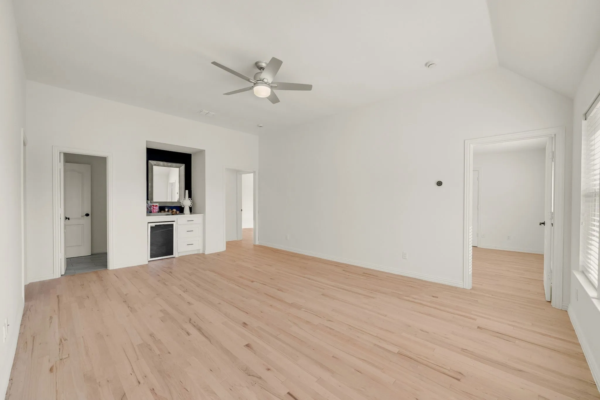Spacious open floor plan with wood-finish flooring throughout, recessed lighting, and ceiling fan