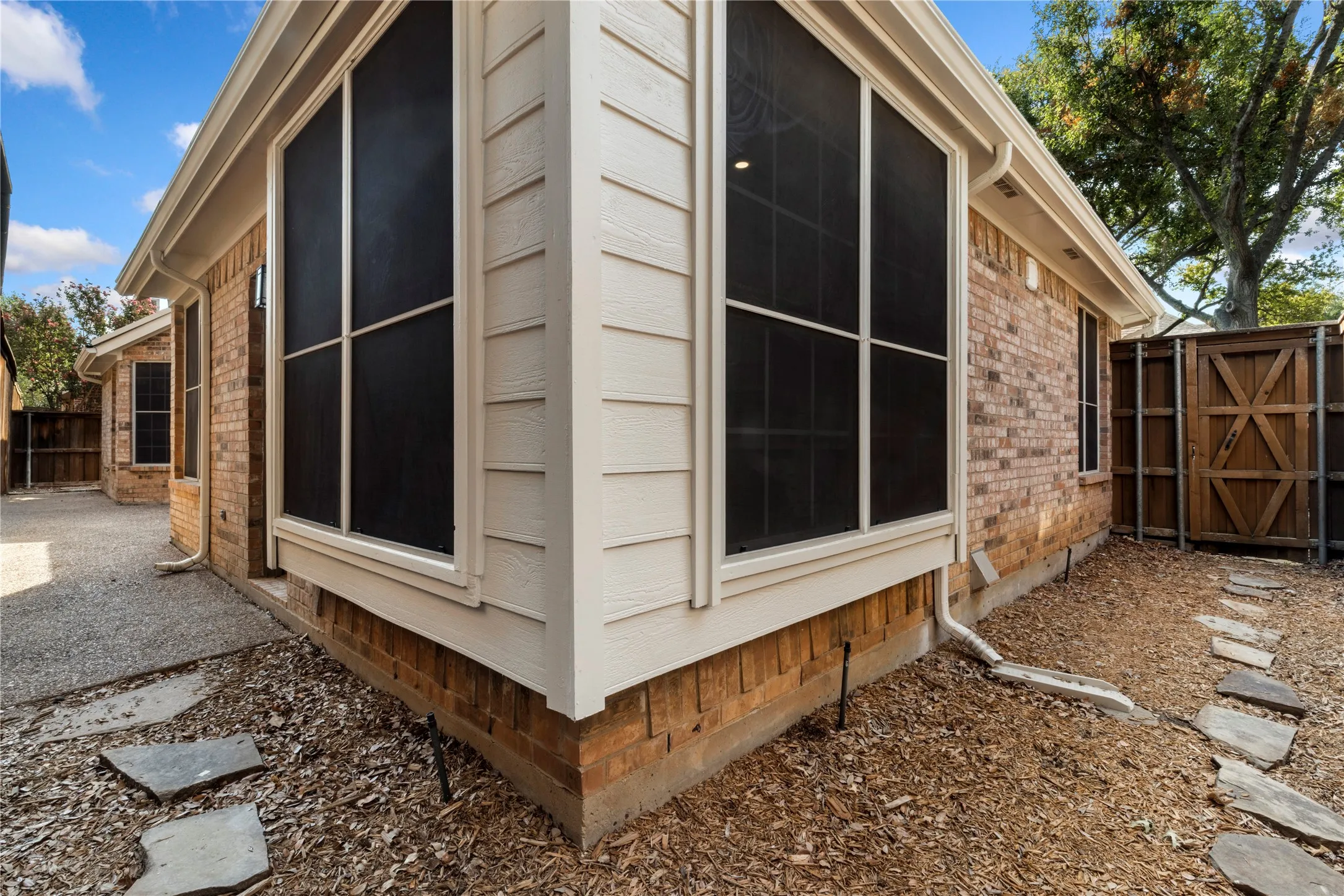 Brick exterior with white siding accents and a bay window