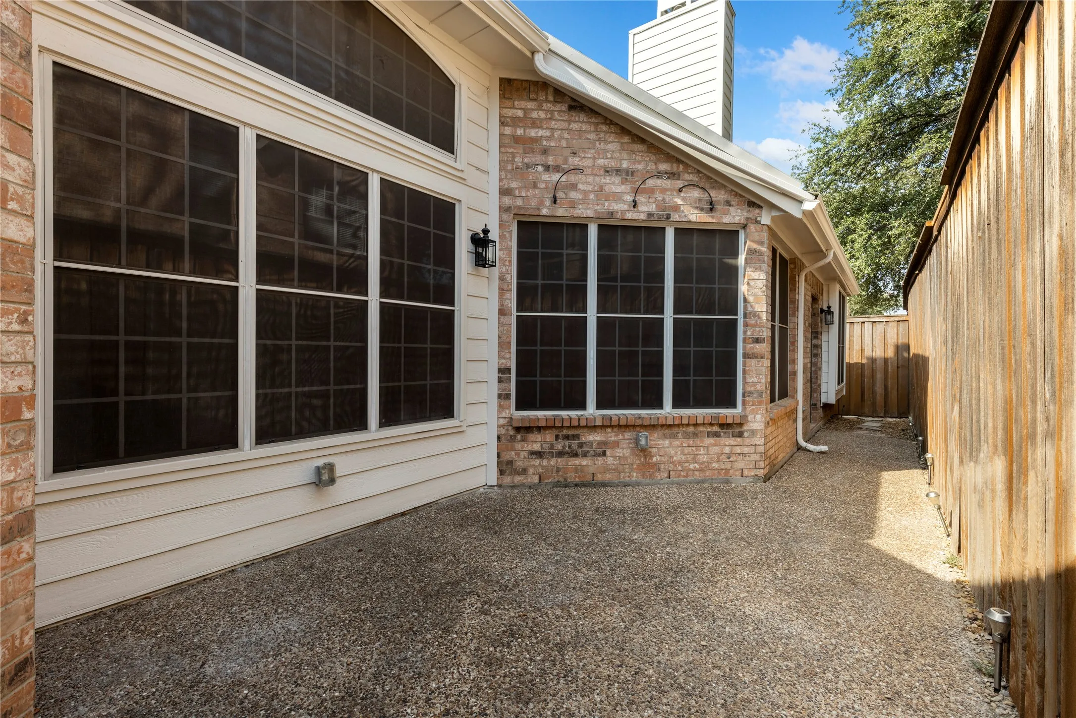 Exposed aggregate patio with brick and siding exterior