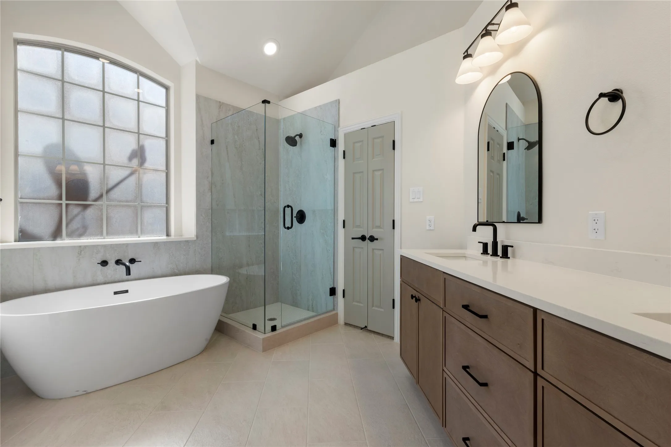 Freestanding soaking tub with wall-mounted fixtures