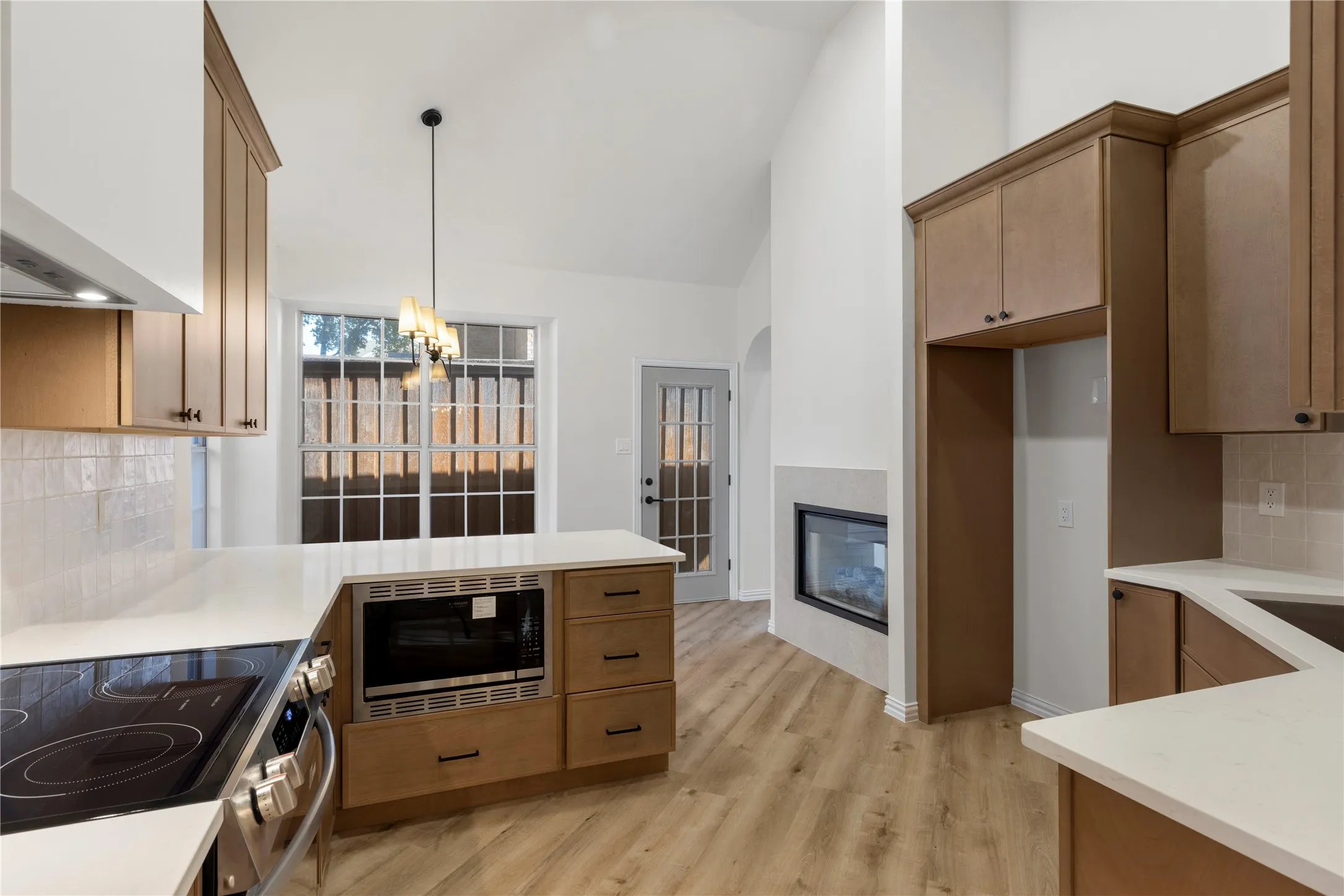 Kitchen featuring wood-finish cabinetry, white countertops, built-in microwave, stainless steel range, and wood-look flooring