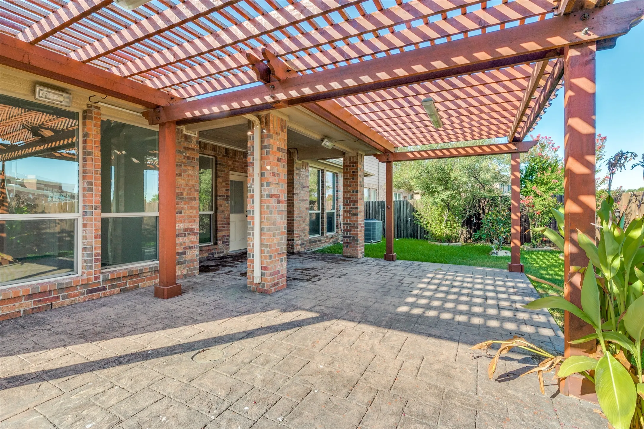 Fenced backyard with a pergola and a patio