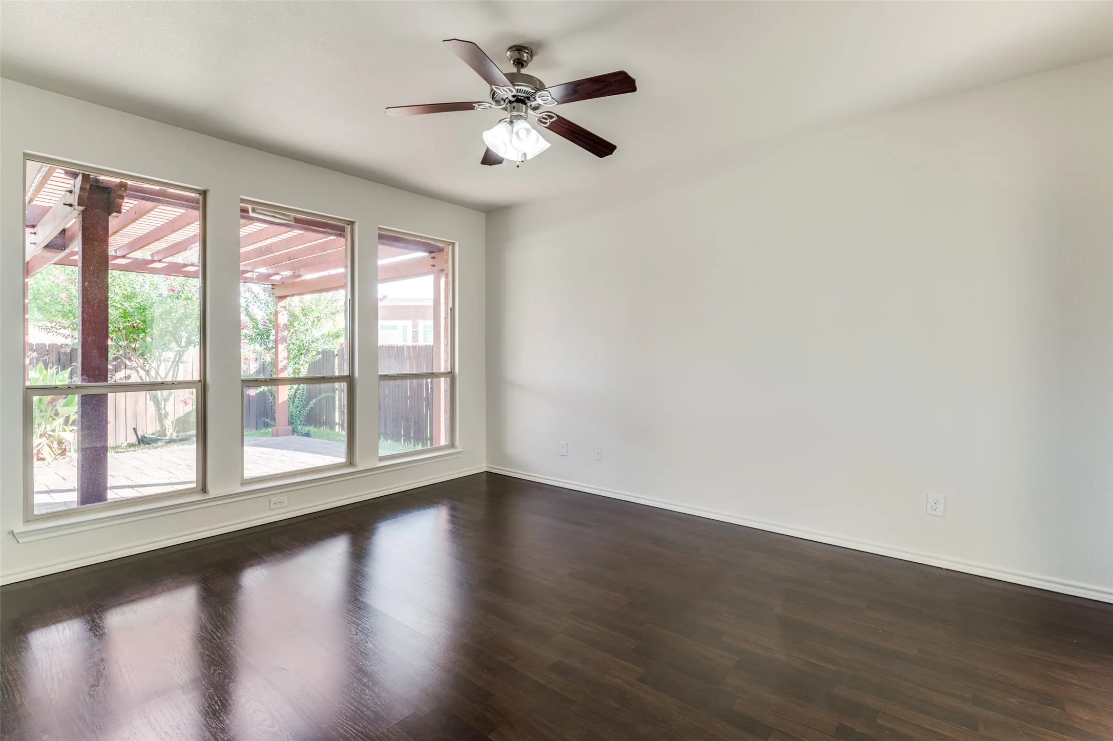 Spare room with dark wood-type flooring and ceiling fan