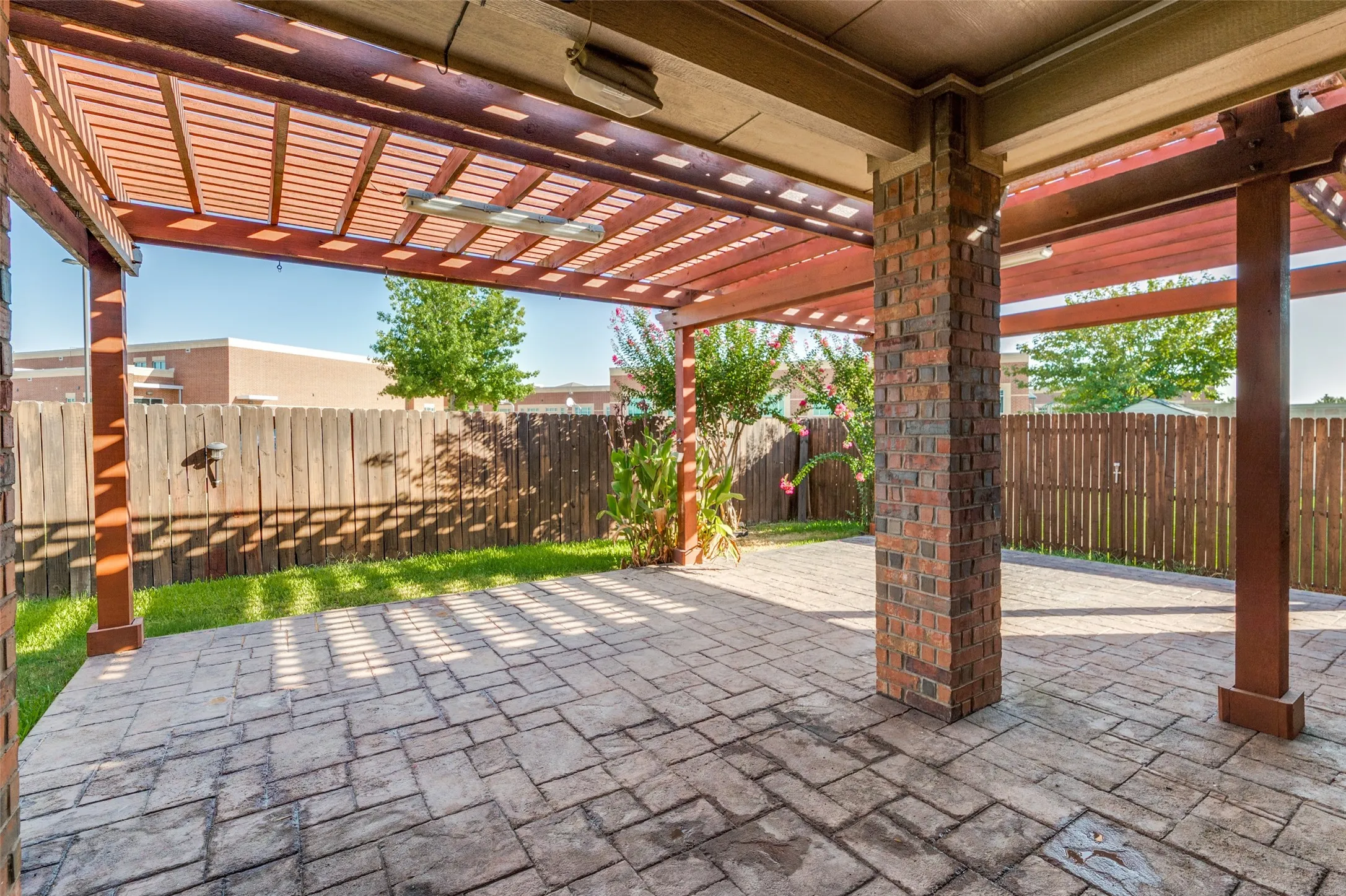 Fenced backyard featuring a pergola and a patio