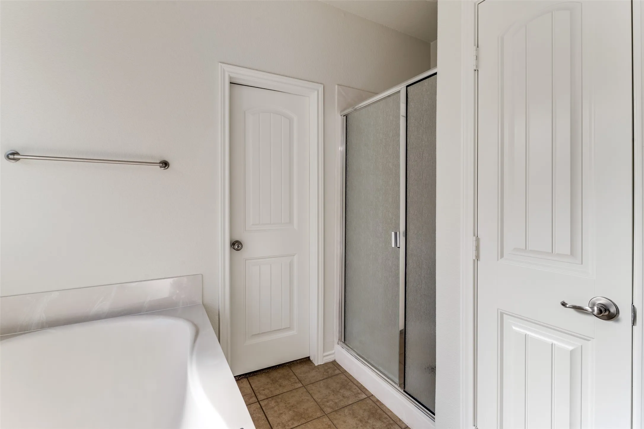Full bathroom featuring a shower stall, a garden tub, and tile patterned floors