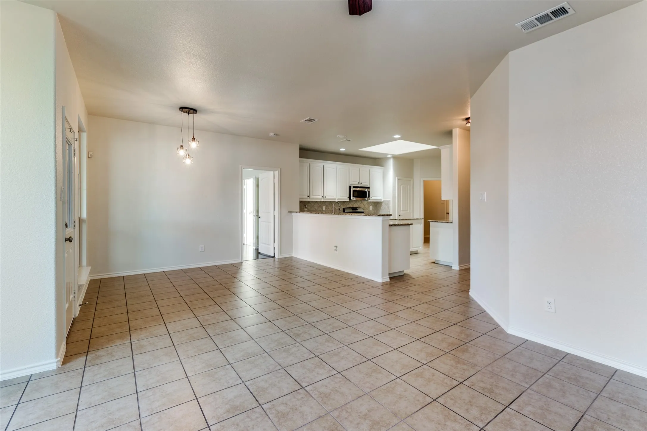 Unfurnished living room with light tile patterned floors and recessed lighting