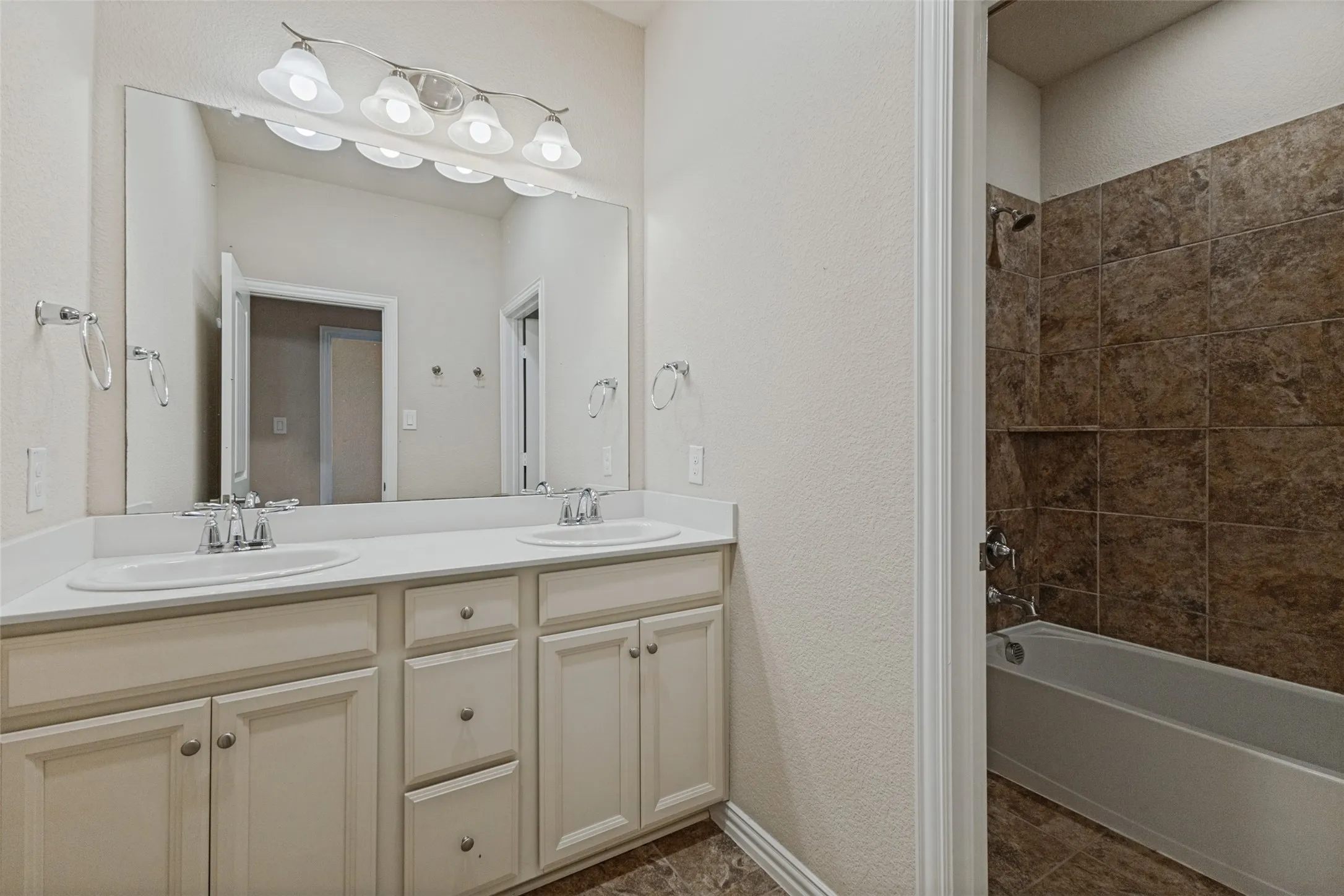 Upstairs bathroom featuring dual vanity with cream cabinetry and polished chrome fixtures
