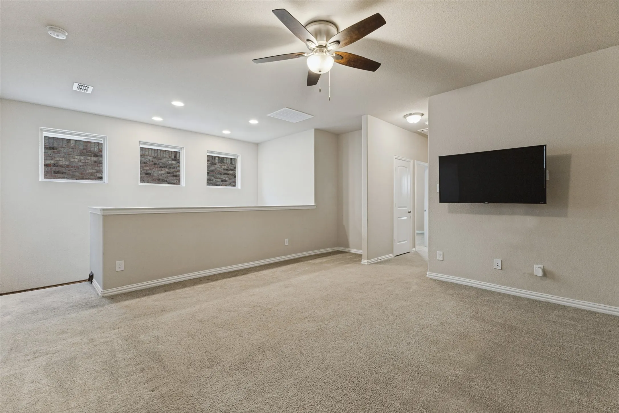 Oversized upstairs game room-living room with a ceiling fan, recessed lighting, and mounted TV