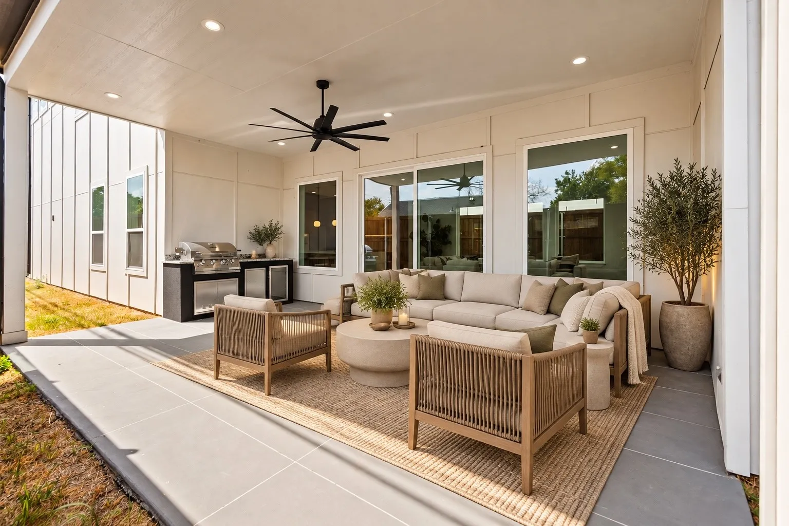 Covered outdoor patio with a ceiling fan, recessed lighting, and a built-in outdoor kitchen with a grill and beverage refrigerators