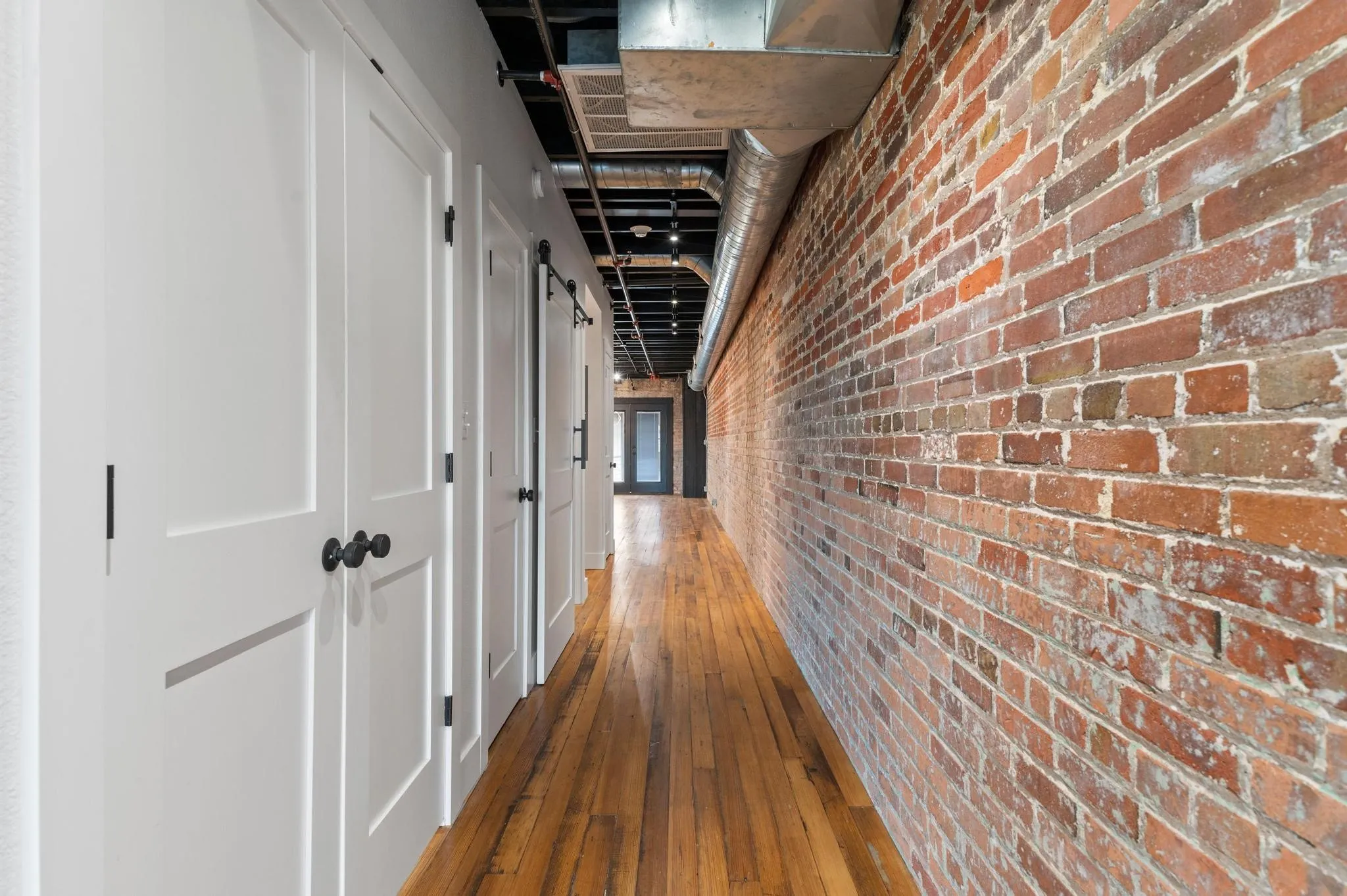 Exposed brick accent wall and hardwood flooring