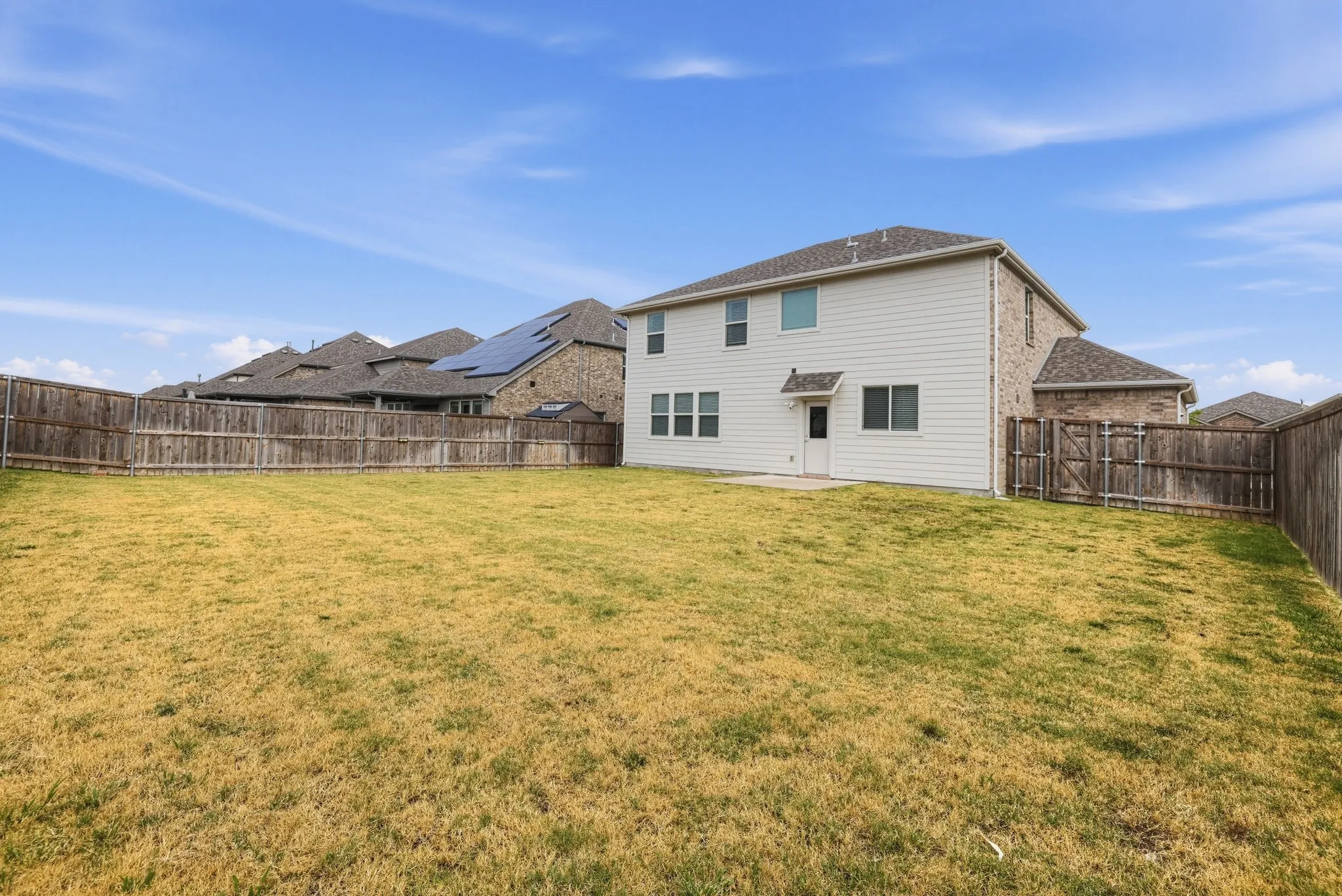 Expansive backyard with a full perimeter wood fence, providing privacy and defined boundaries