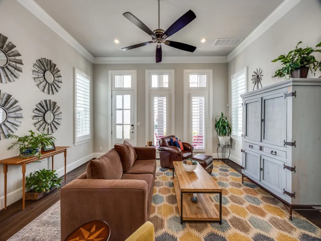 Hardwood flooring, crown molding, ceiling fan, recessed lighting, and multiple windows with plantation shutters