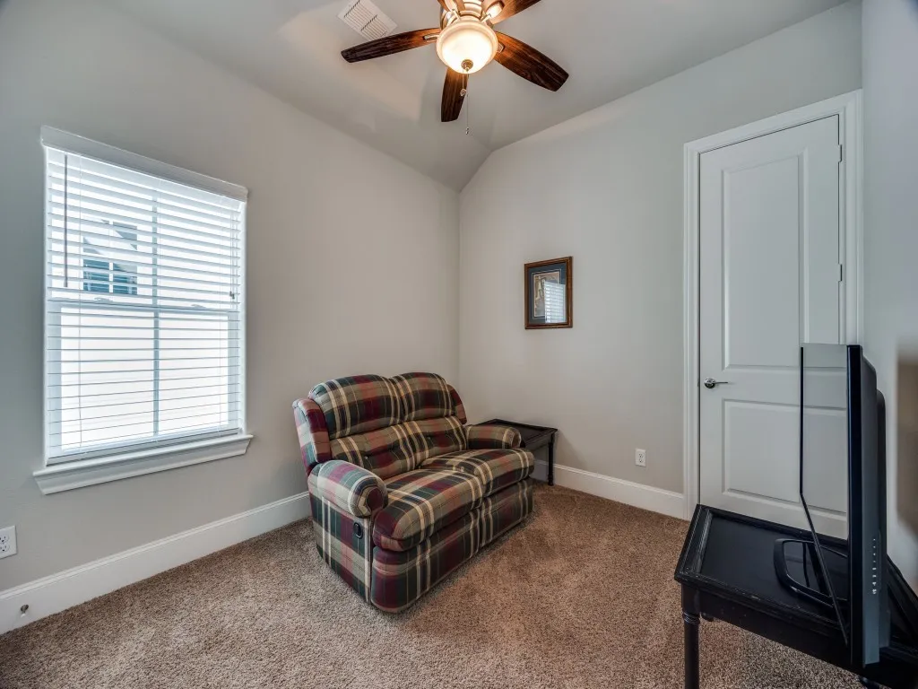 Carpeted flooring, a window with blinds, a ceiling fan with integrated lighting, a paneled door, and neutral wall paint