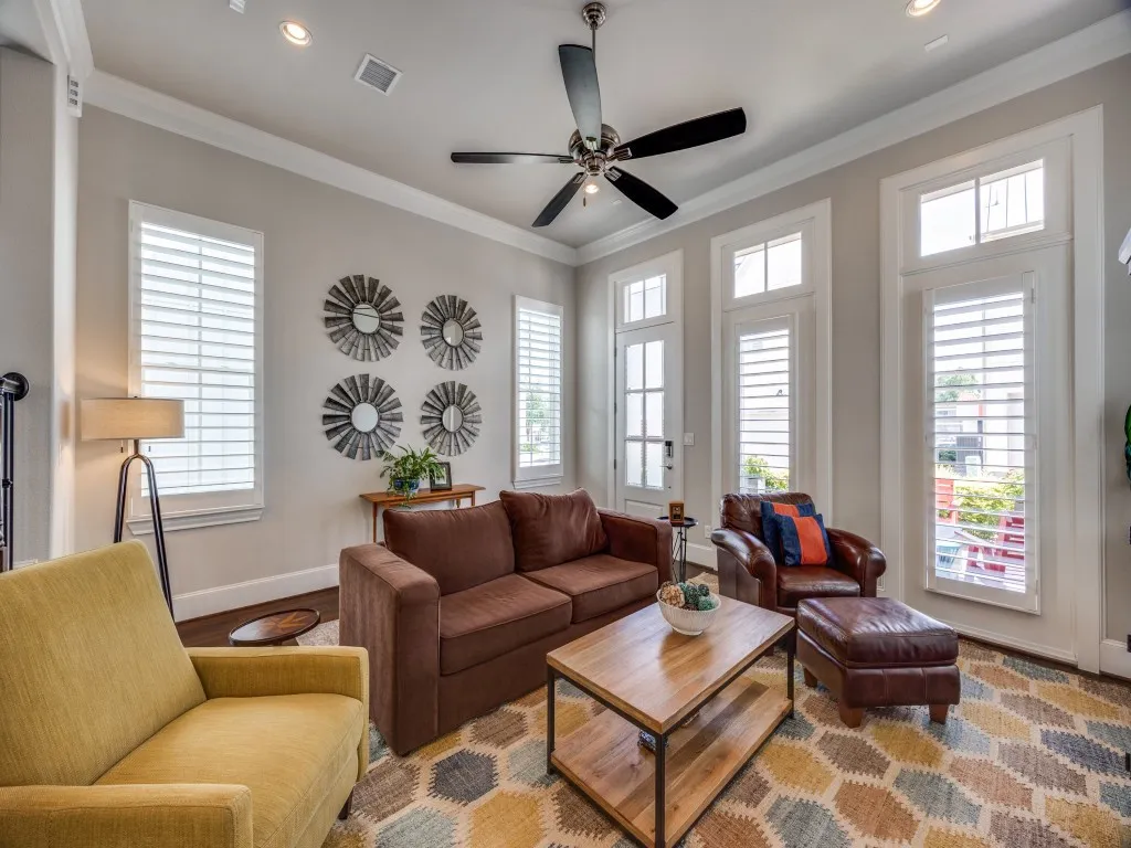 Recessed lighting, crown molding, ceiling fan, multiple windows with plantation shutters, and wood-finish flooring