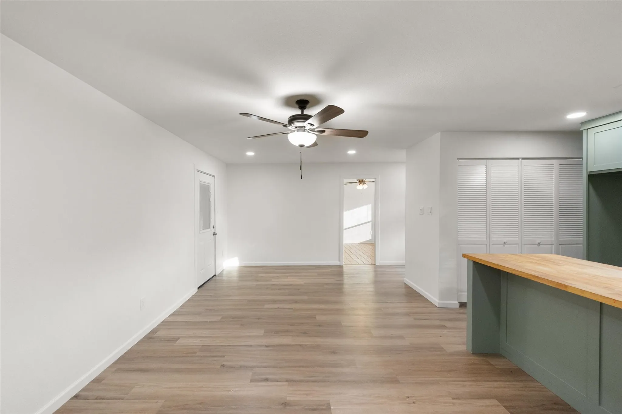 View of the living area featuring wood like ceramic tile, LED lights and ceiling fan.