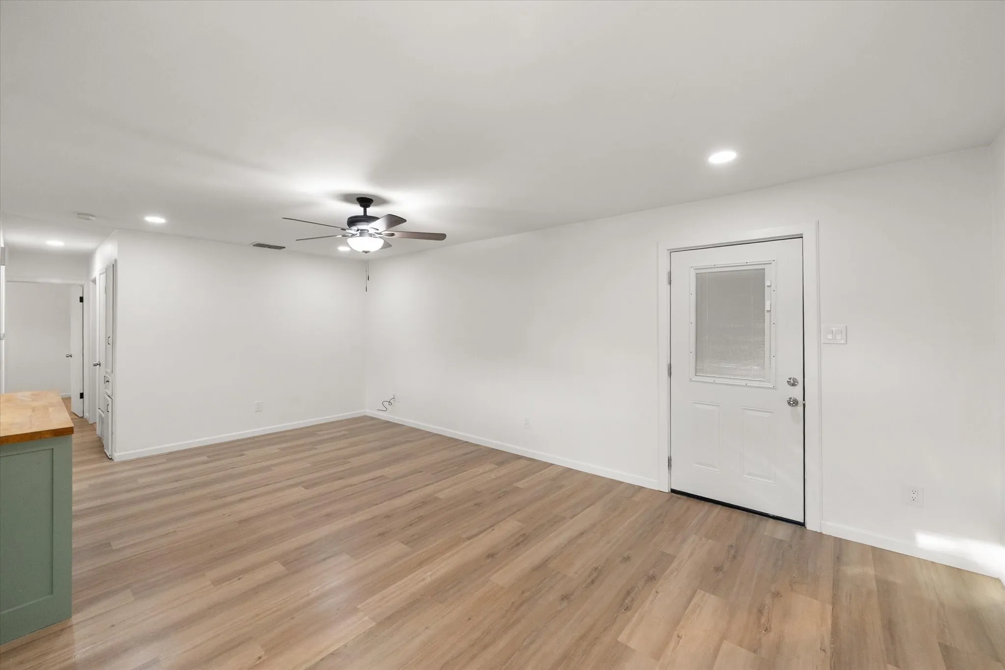 View of the living area featuring wood like ceramic tile, LED lights and ceiling fan.