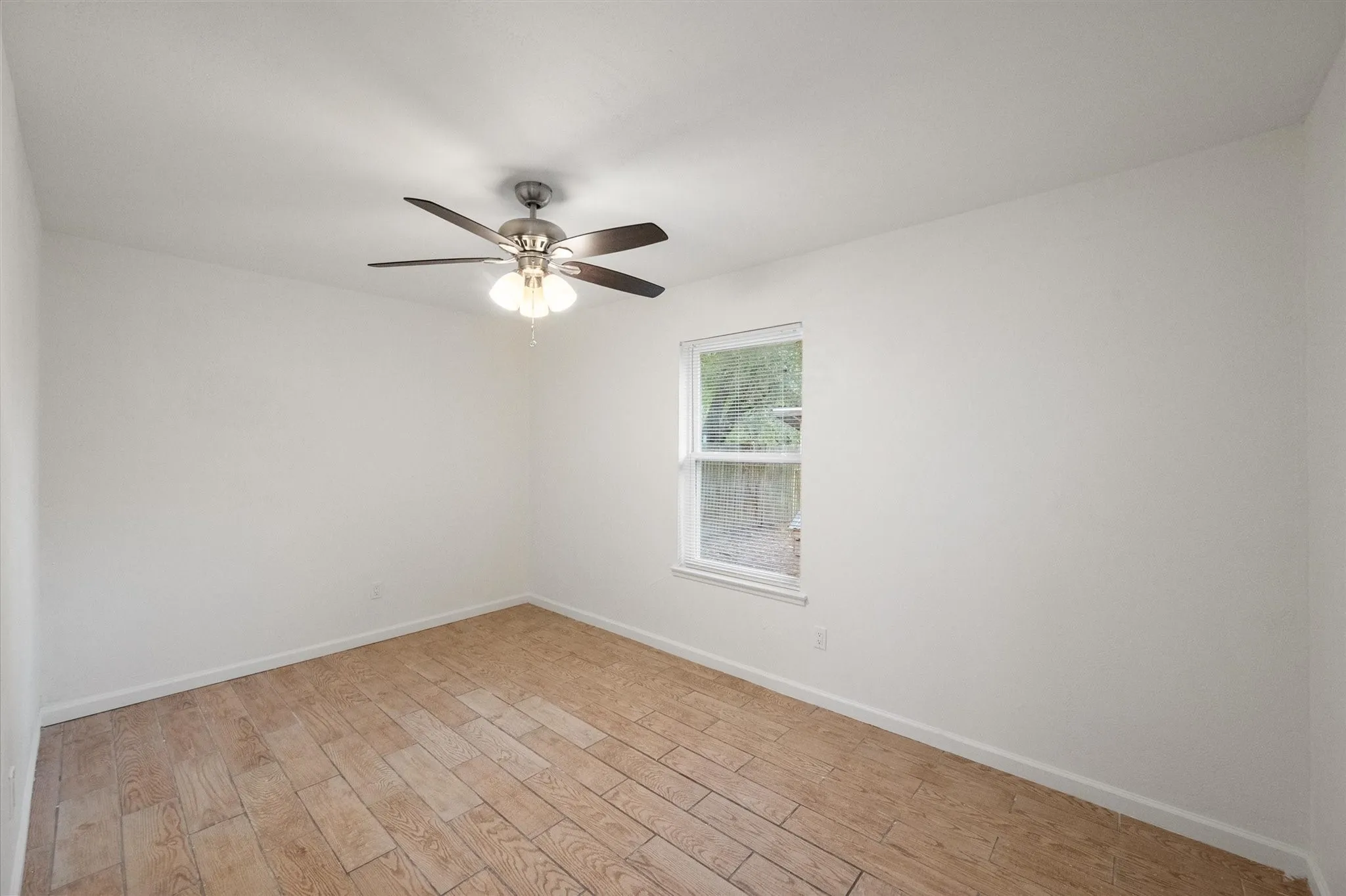 Secondary bedroom featuring wood like ceramic tile flooring.