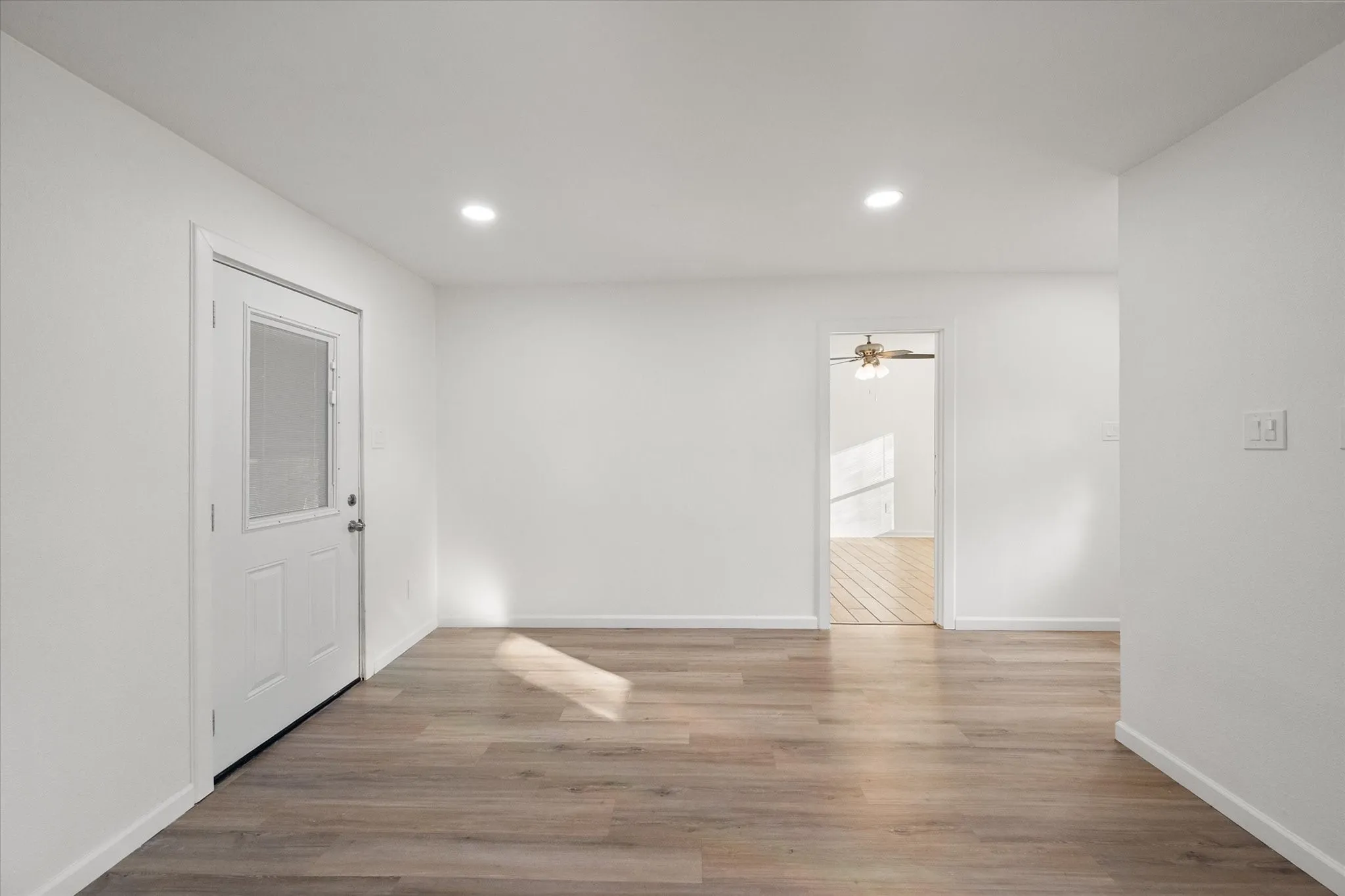 View of the living area featuring wood like ceramic tile, LED lights and ceiling fan.