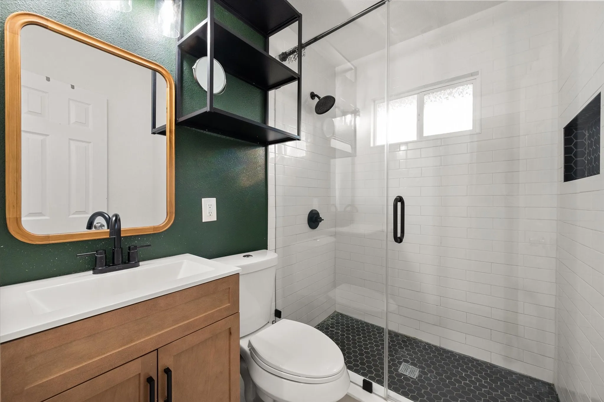 Ceramic tile and frameless shower with upgraded luxury vanity and black matte harware.