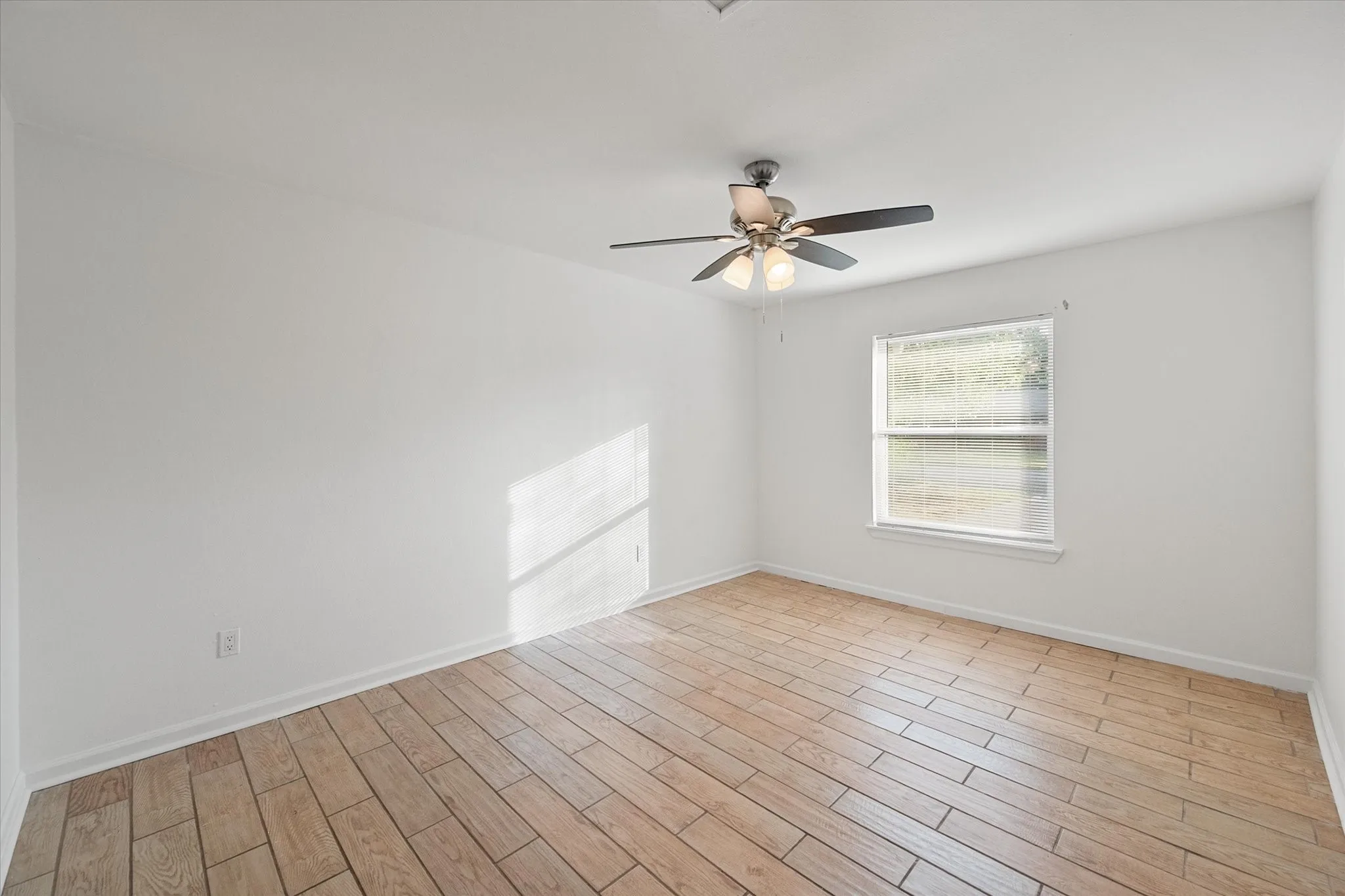 Primary bedroom featuring wood like ceramic tile flooring.