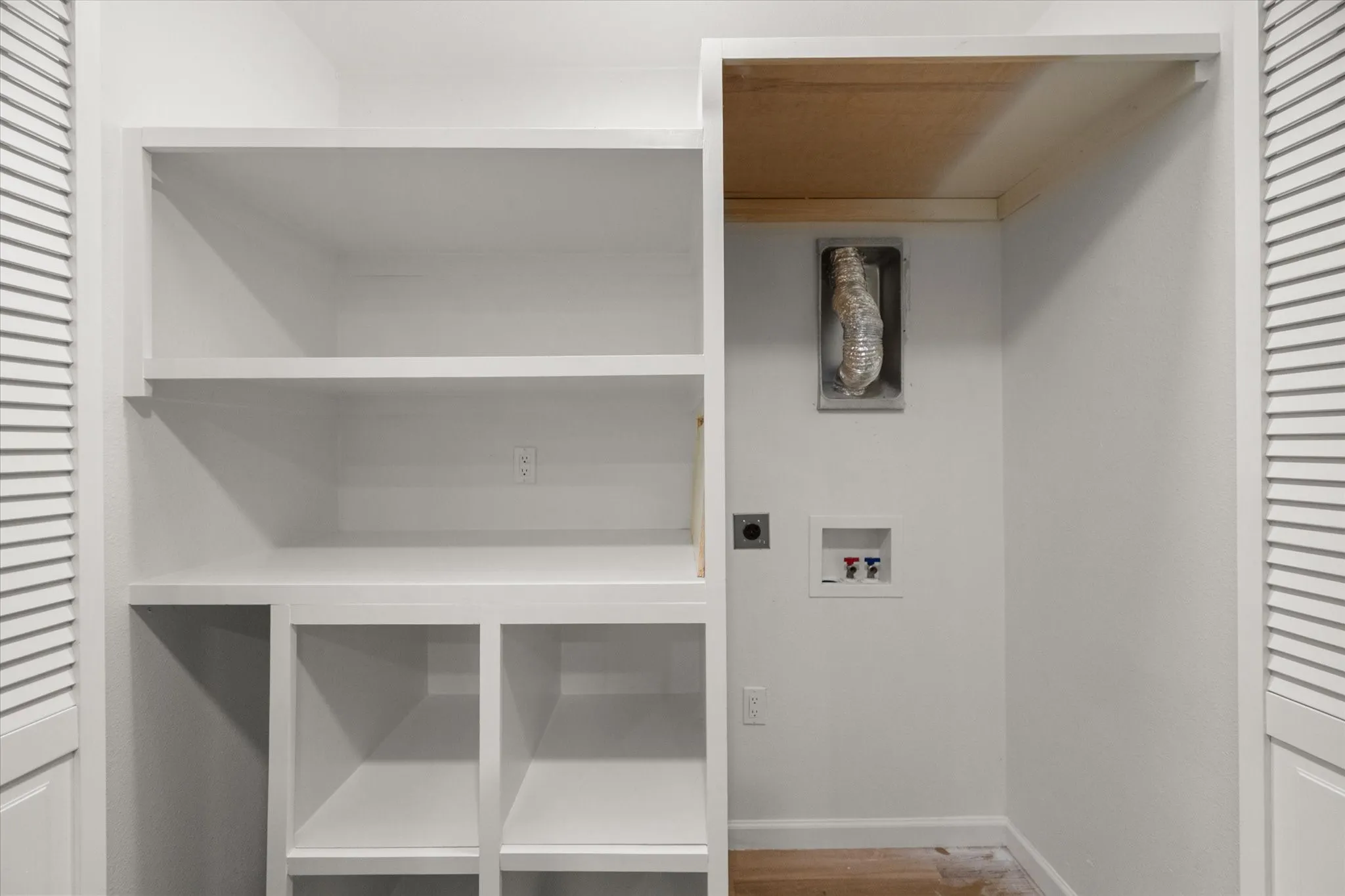 Located in kichen. Stacked washer and dryer connections and build in shelving