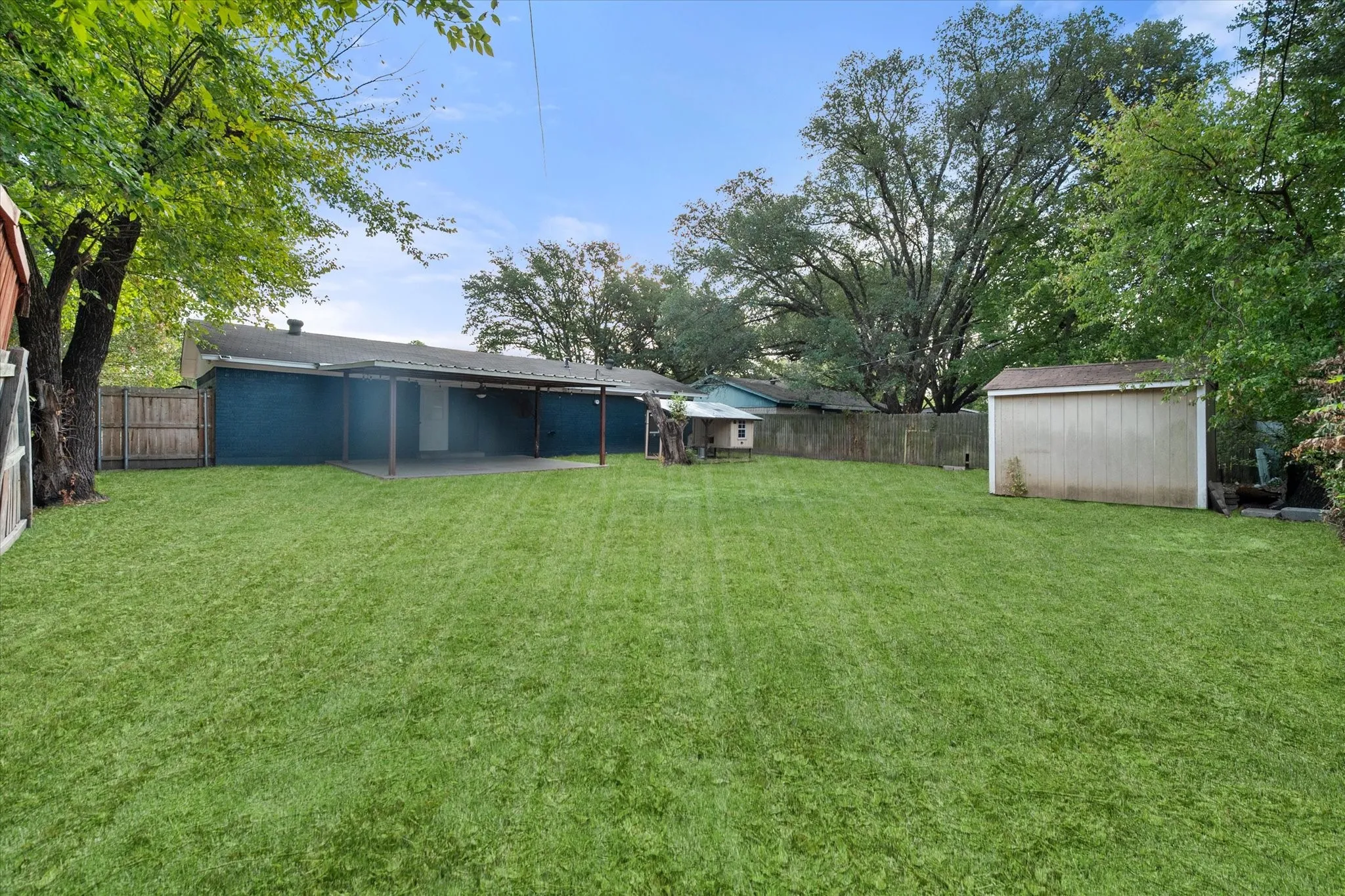 Spacious backyard with a covered patio.
