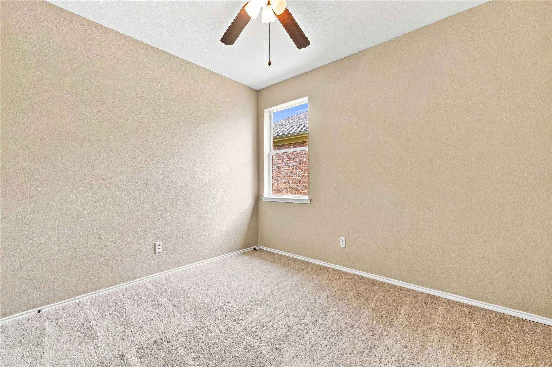Wall-to-wall carpeting with light-toned walls, a single window, and a ceiling fan with integrated lighting