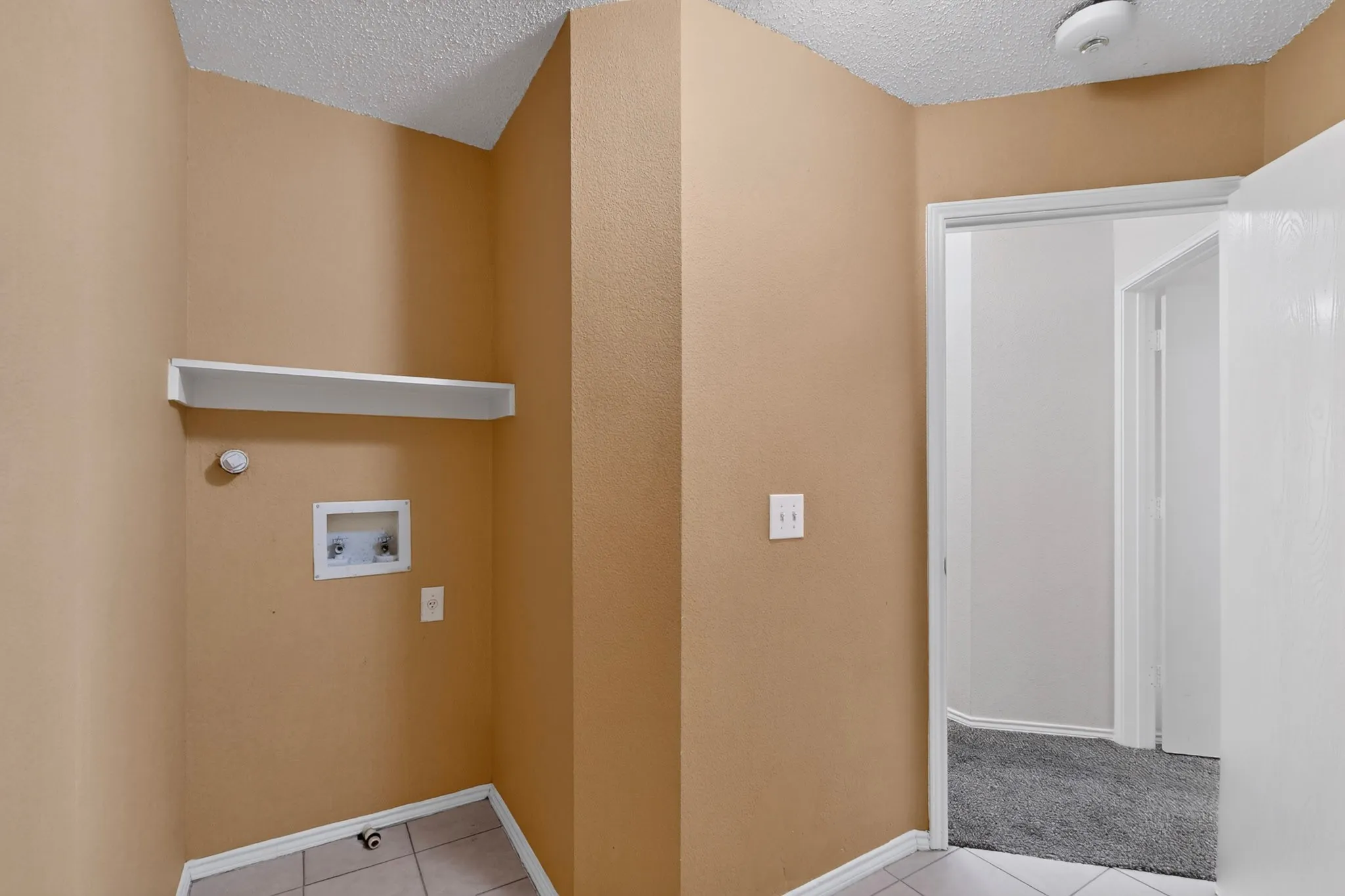 Separated laundry room with shelf, and appliance hookups