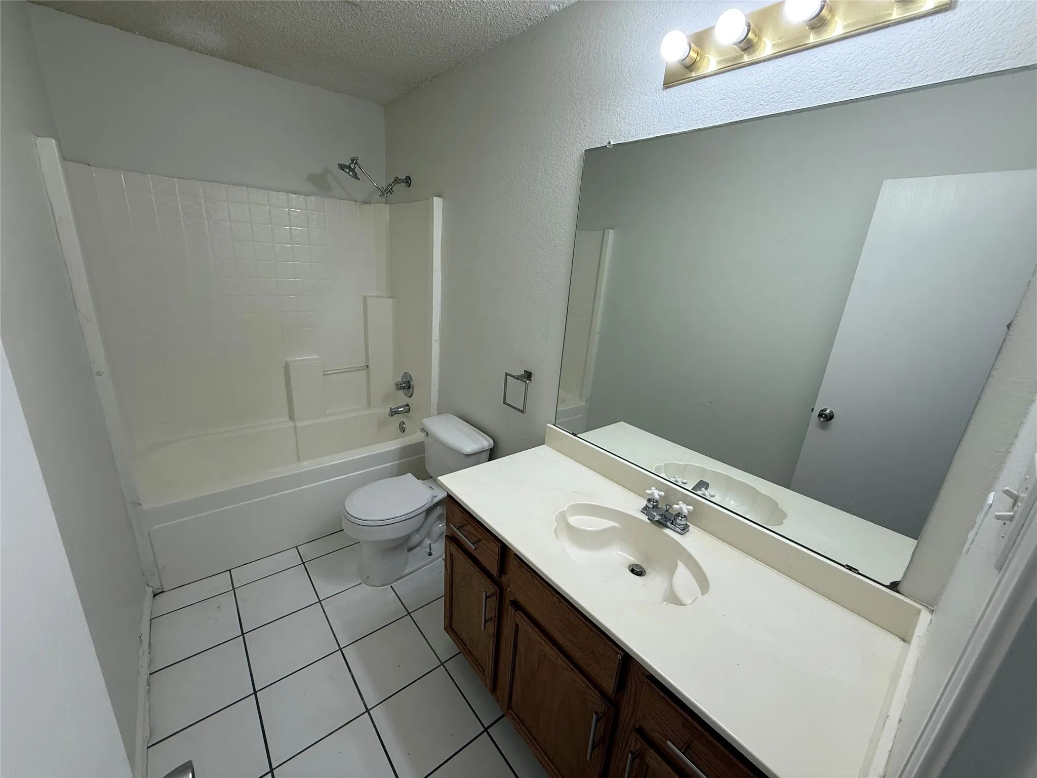 Full bath with a tub/shower combination, vanity with integrated sink, and tile flooring