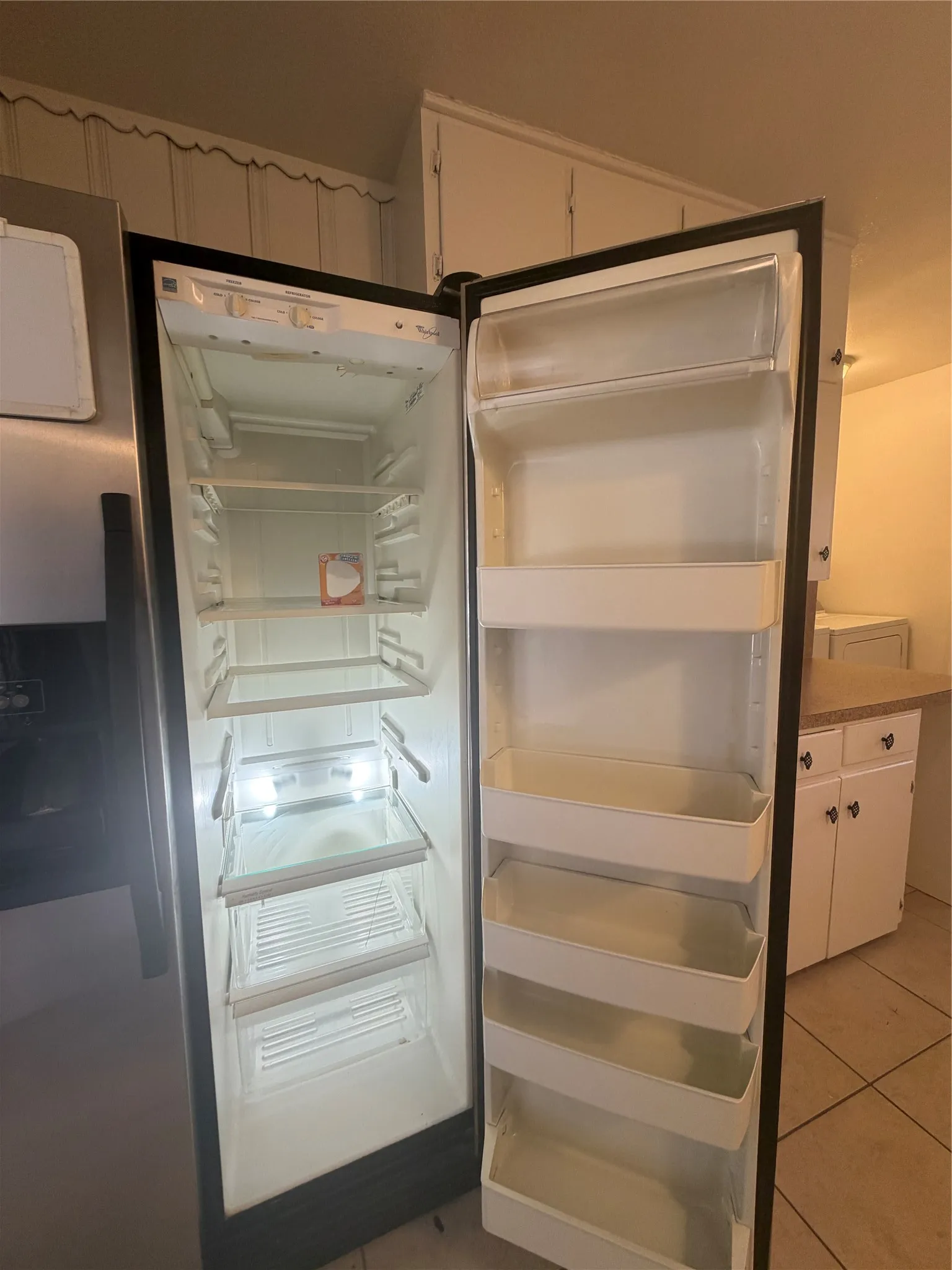 Stainless steel refrigerator with a built-in ice and water dispenser, adjustable interior shelving, and door storage