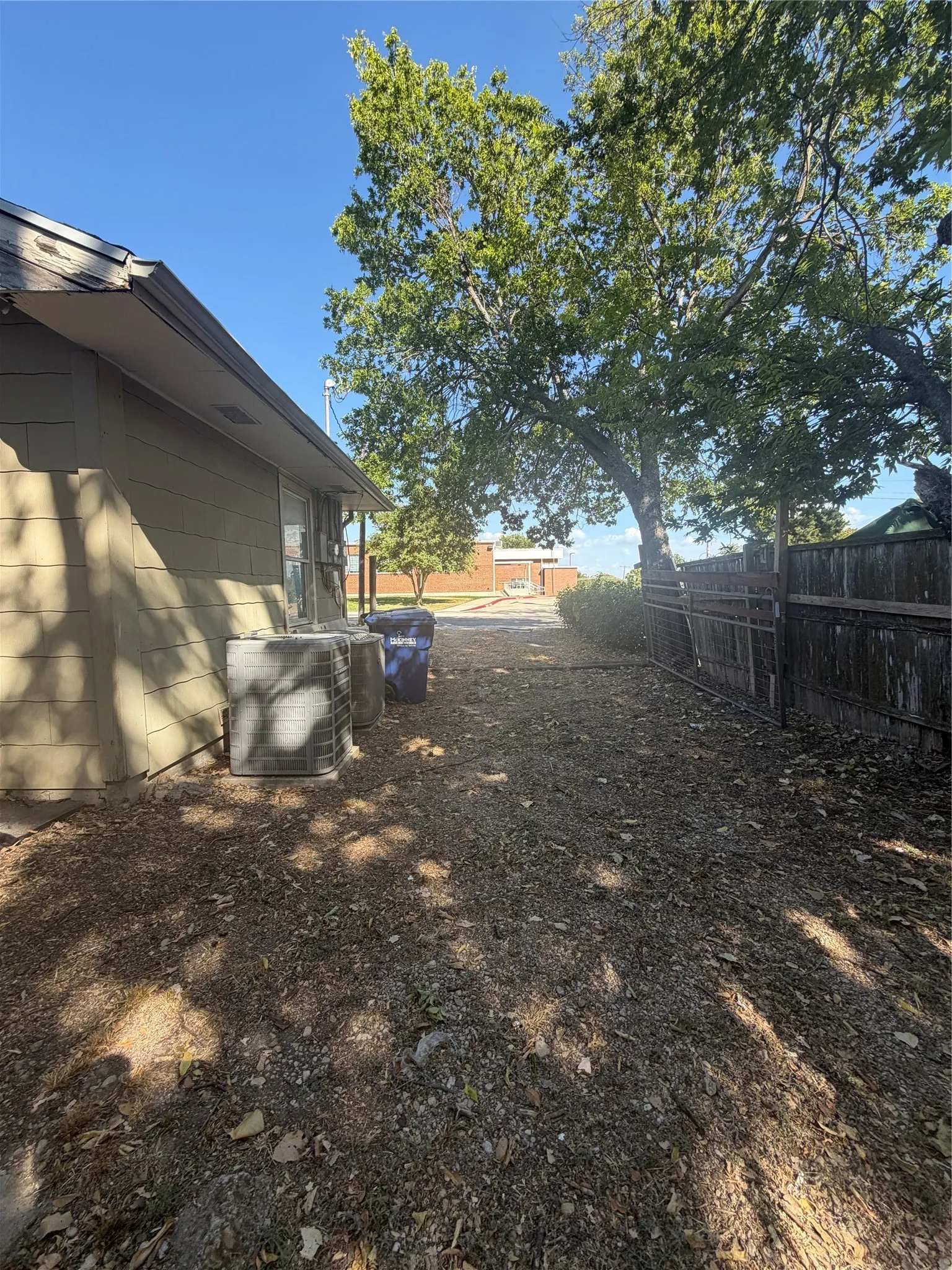 Exterior siding, mature trees, and a privacy fence
