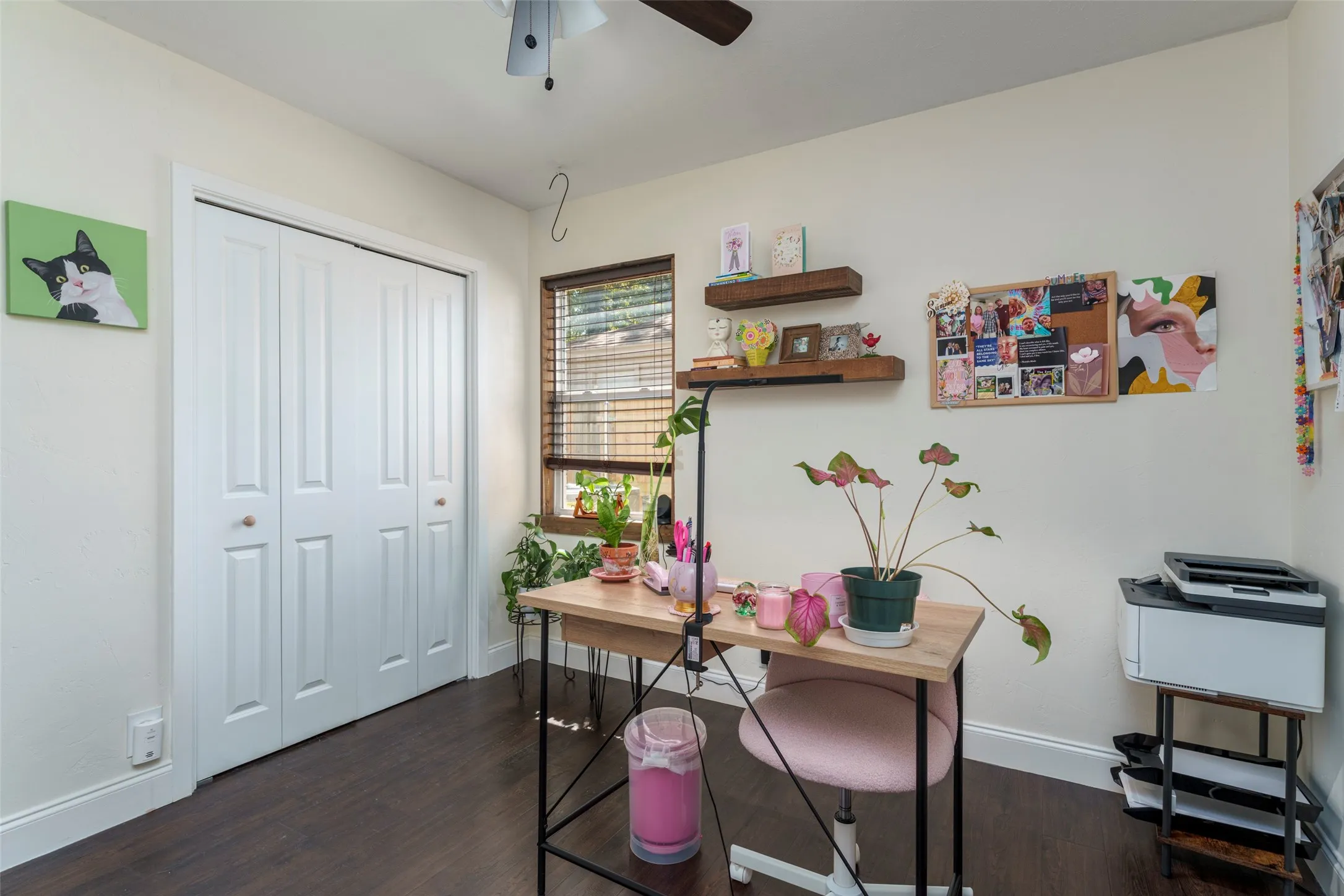 Wood-finish flooring with white baseboards, white walls, and a ceiling fan