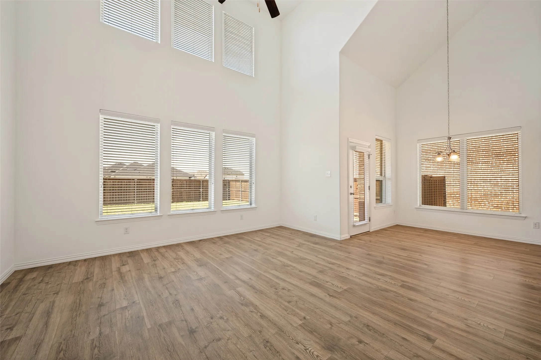 Soaring vaulted ceilings and wood-finish flooring enhance this expansive room