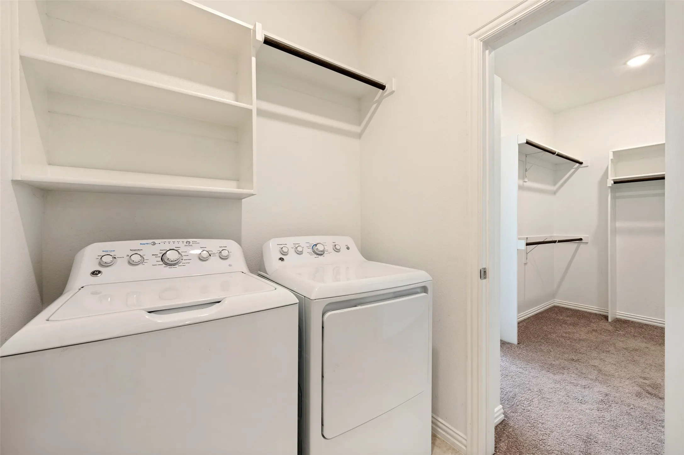 Laundry area featuring built-in shelving and a clothing rod