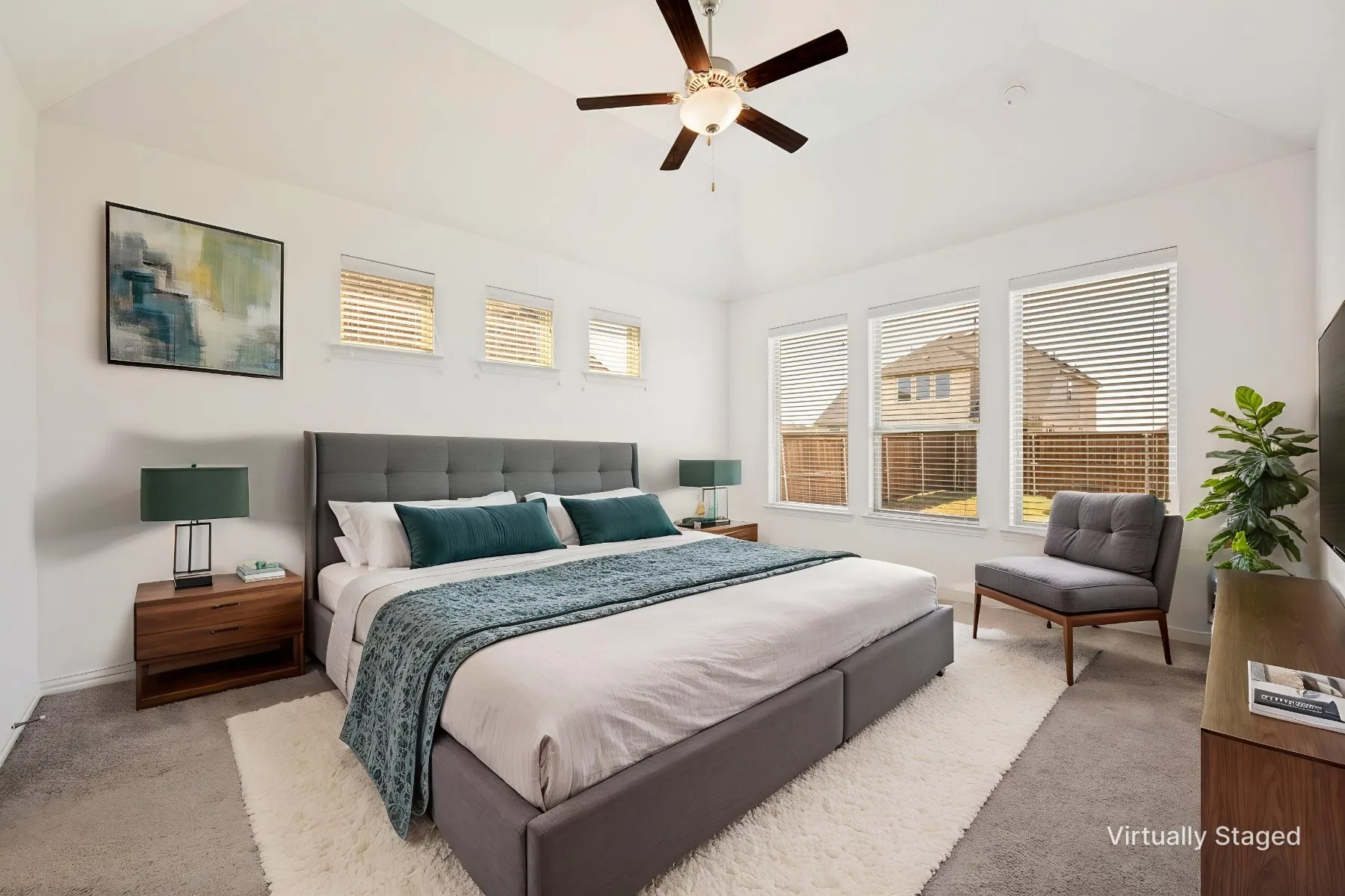 Vaulted ceiling with ceiling fan, large windows with blinds, and white walls