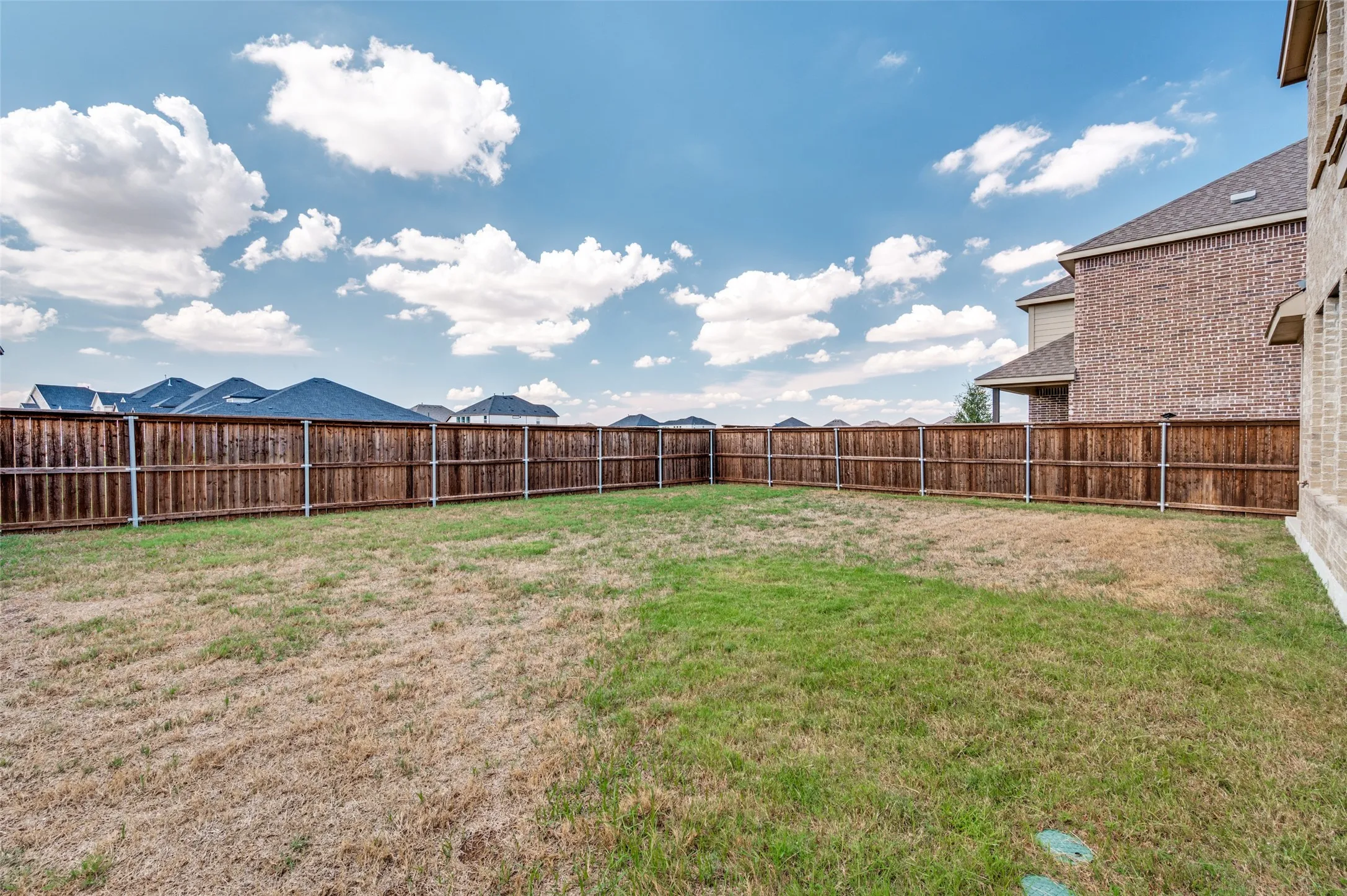Expansive backyard with a full perimeter wood fence