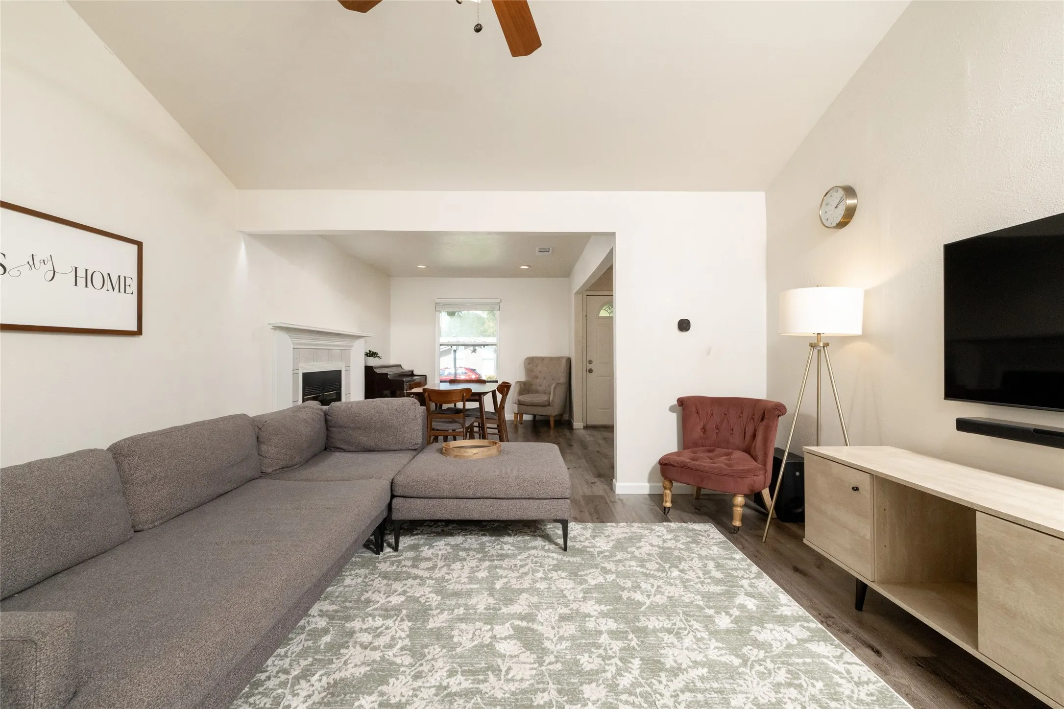Vaulted ceiling, wood-finish flooring, built-in fireplace with mantel, recessed lighting, ceiling fan