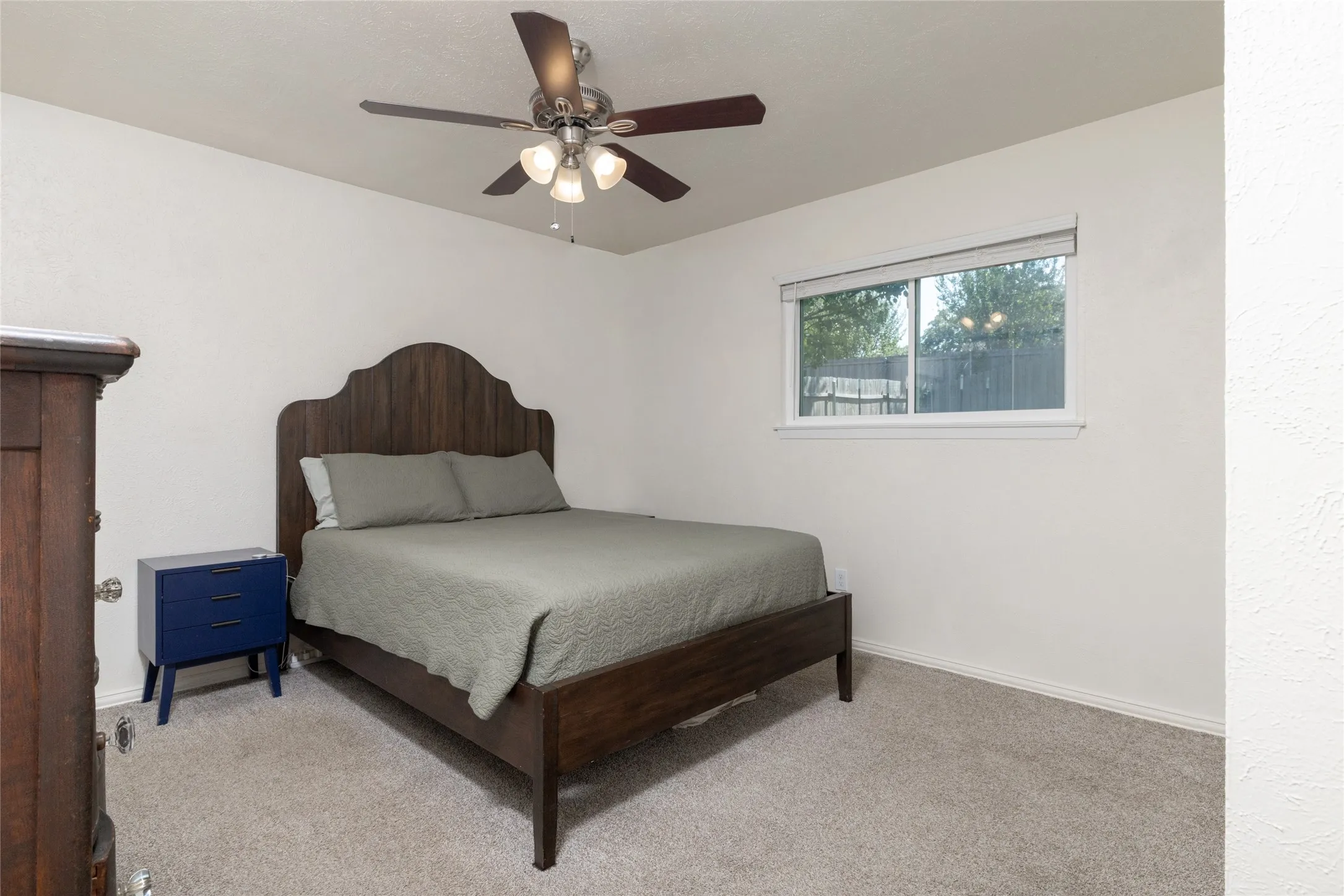 Wall-to-wall carpeting and a ceiling fan with integrated lighting
