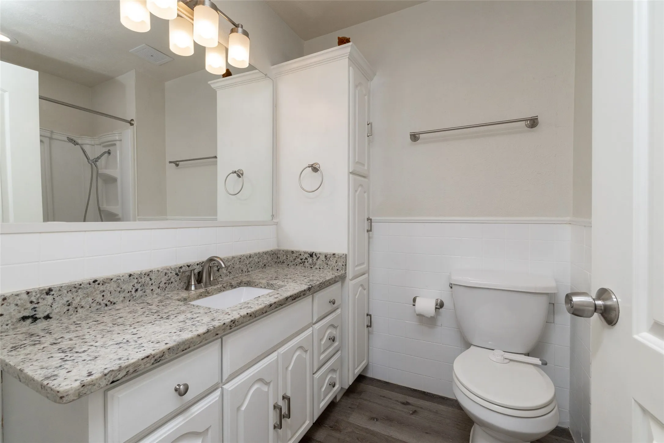 Vanity with a speckled countertop, undermount sink, and brushed nickel faucet