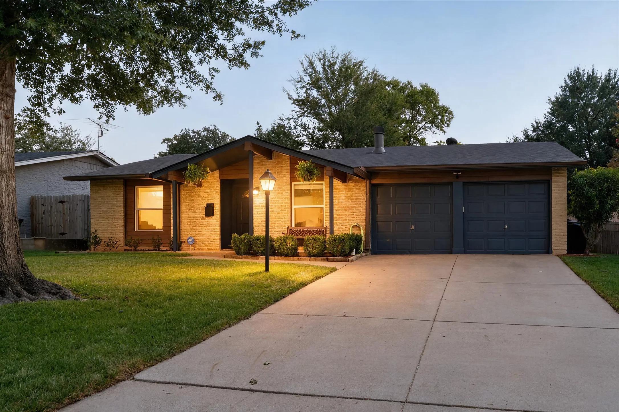 Brick exterior with a dark-toned roof, two-car garage, and concrete driveway