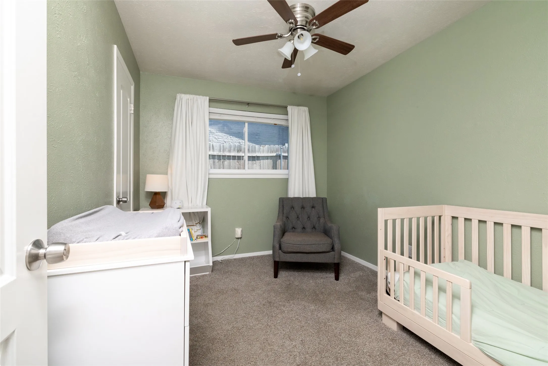 Wall-to-wall carpeting and a ceiling fan with integrated lighting
