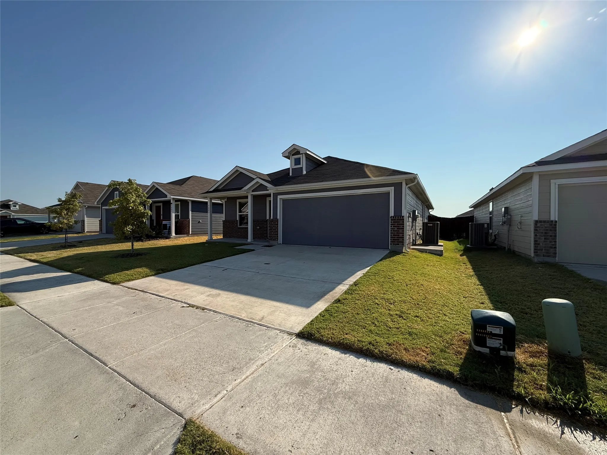 Single-story residence featuring a two-car garage, dormer window, and covered front entry