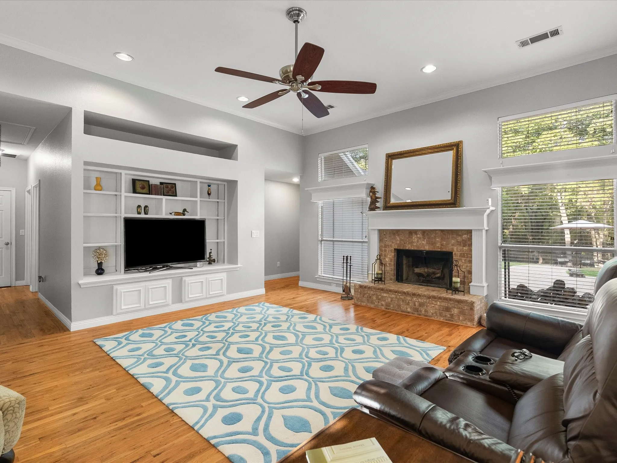 Living Room with built-in bookshelves, fireplace and huge windows overlooking the back yard