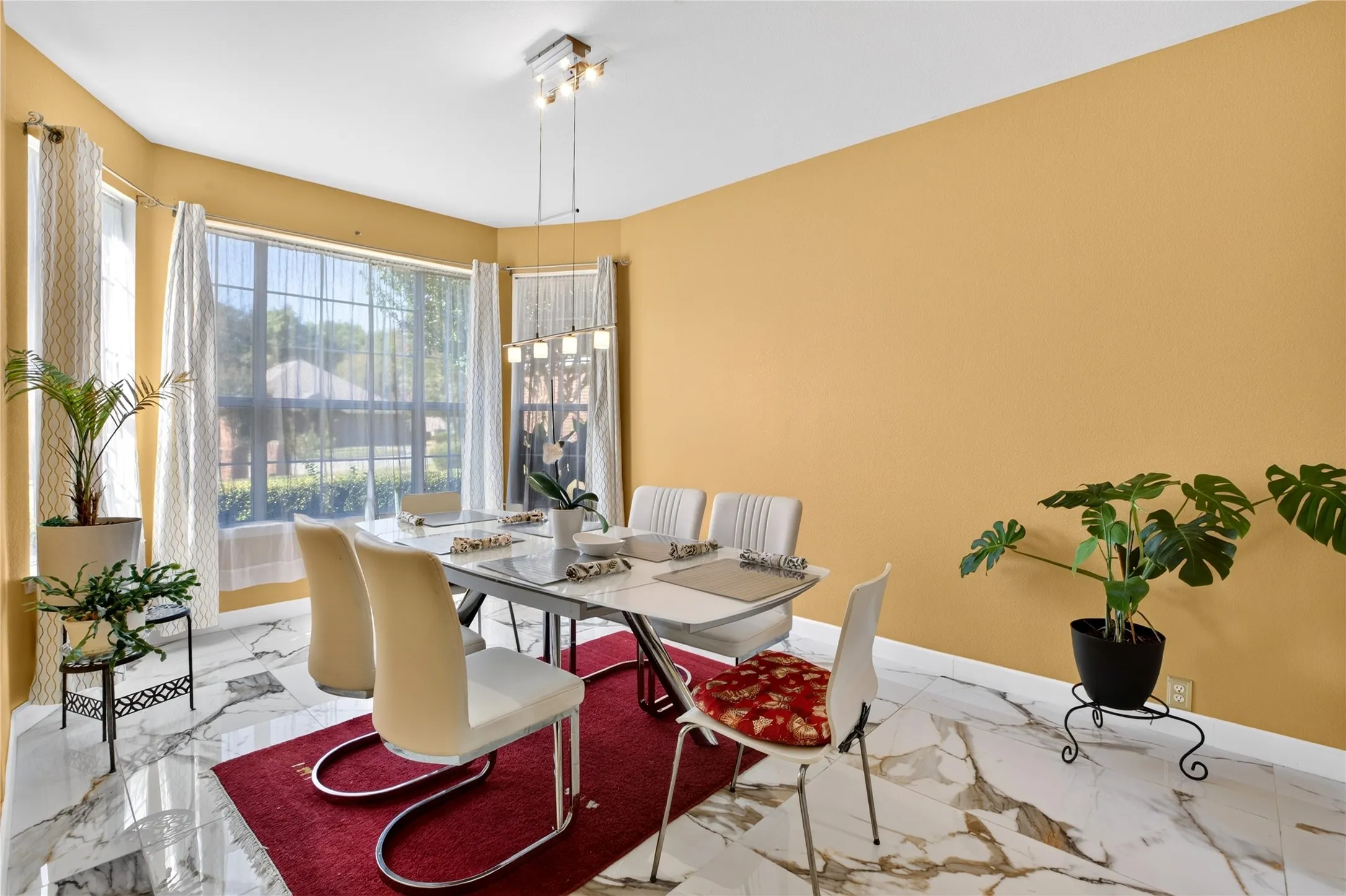 Recessed ceiling with a modern hanging light fixture, large windows with sheer drapes, and high-gloss tile flooring