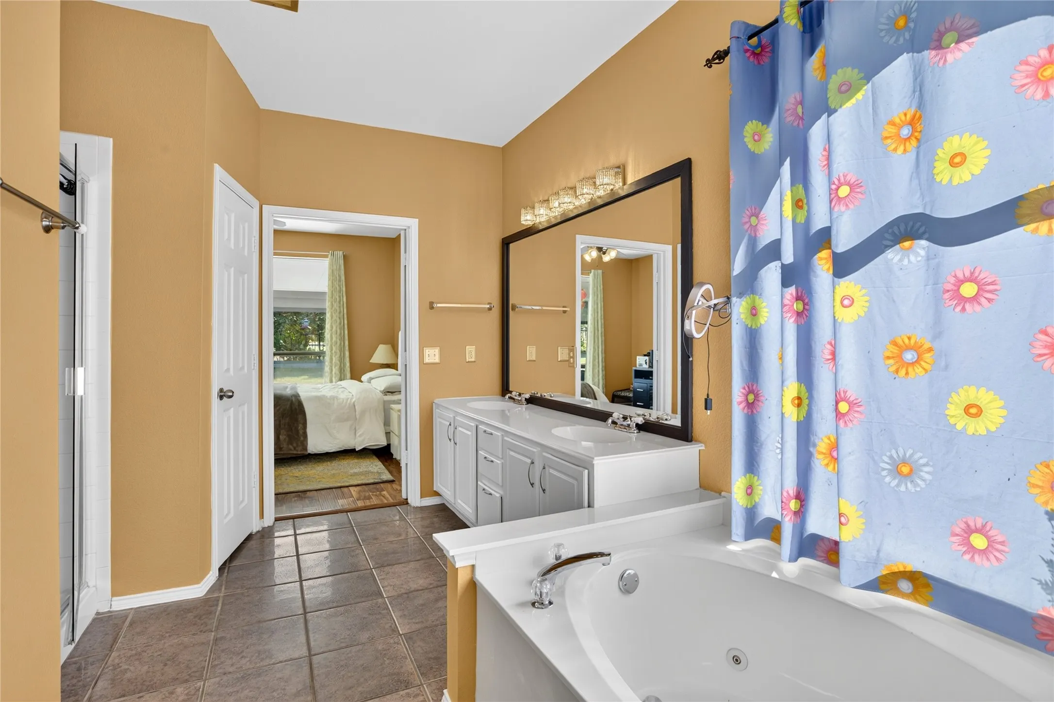 Double vanity with white cabinetry, framed mirror, and integrated lighting